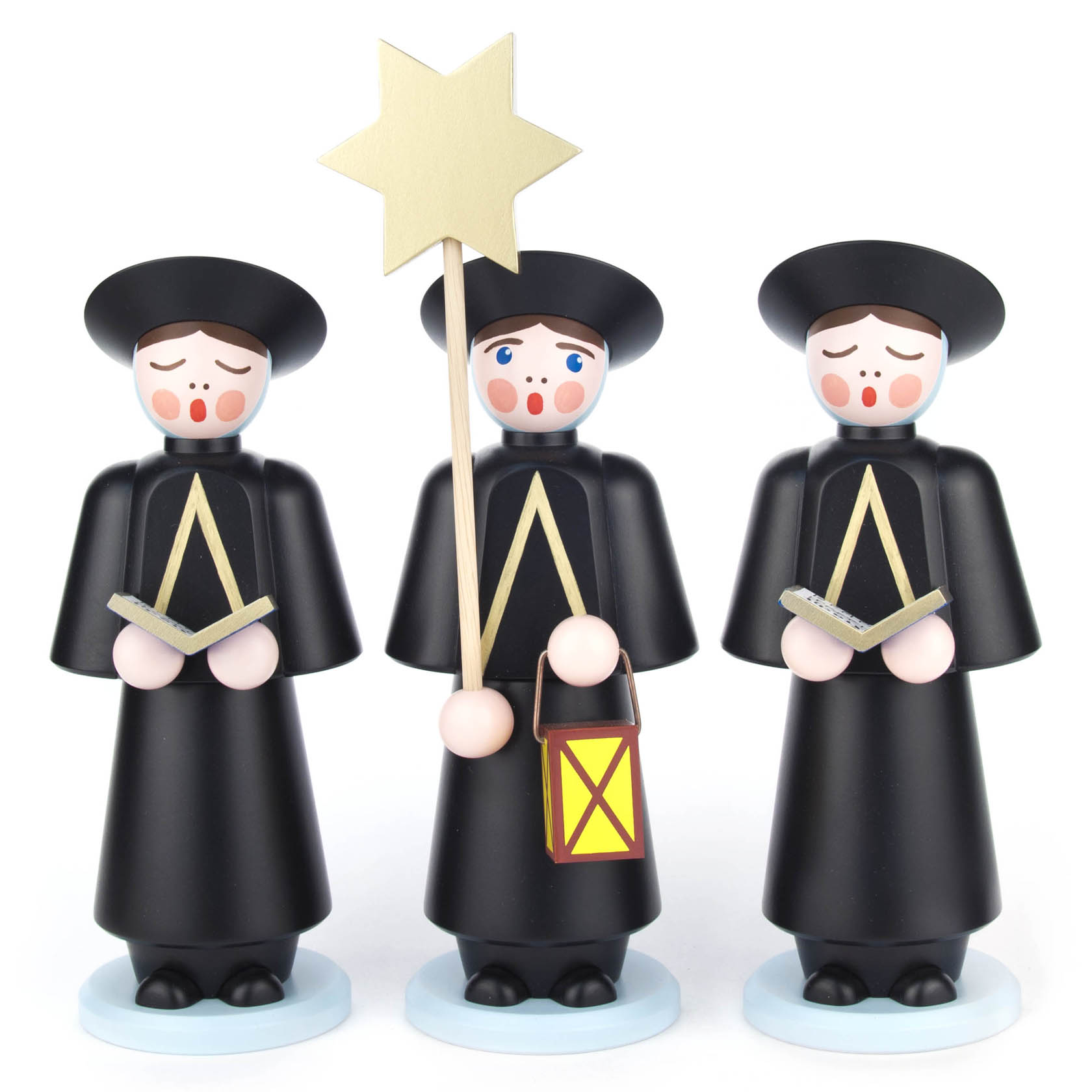 Drei schwarze Kurrendefiguren aus Holz, 32 cm hoch, mit traditionellen runden Hüten und roten Wangen, halten Bücher; eine Figur trägt eine Laterne und einen Stern. im Dregeno Online Shop günstig kaufen