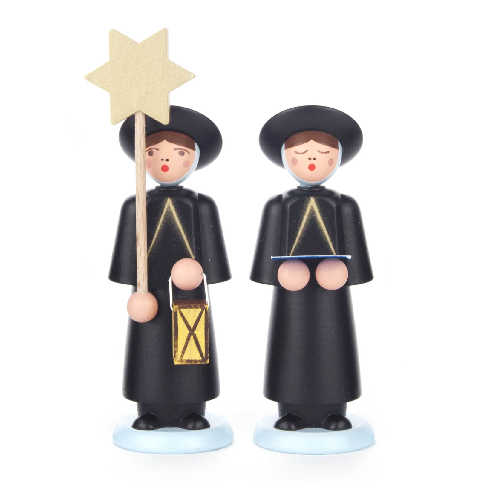 Zwei schwarze Kurrendefiguren mit runden Hüten und Trachten. Eine hält einen goldenen Stern und Laterne, die andere ein Buch. Beide stehen auf blauen Sockeln.