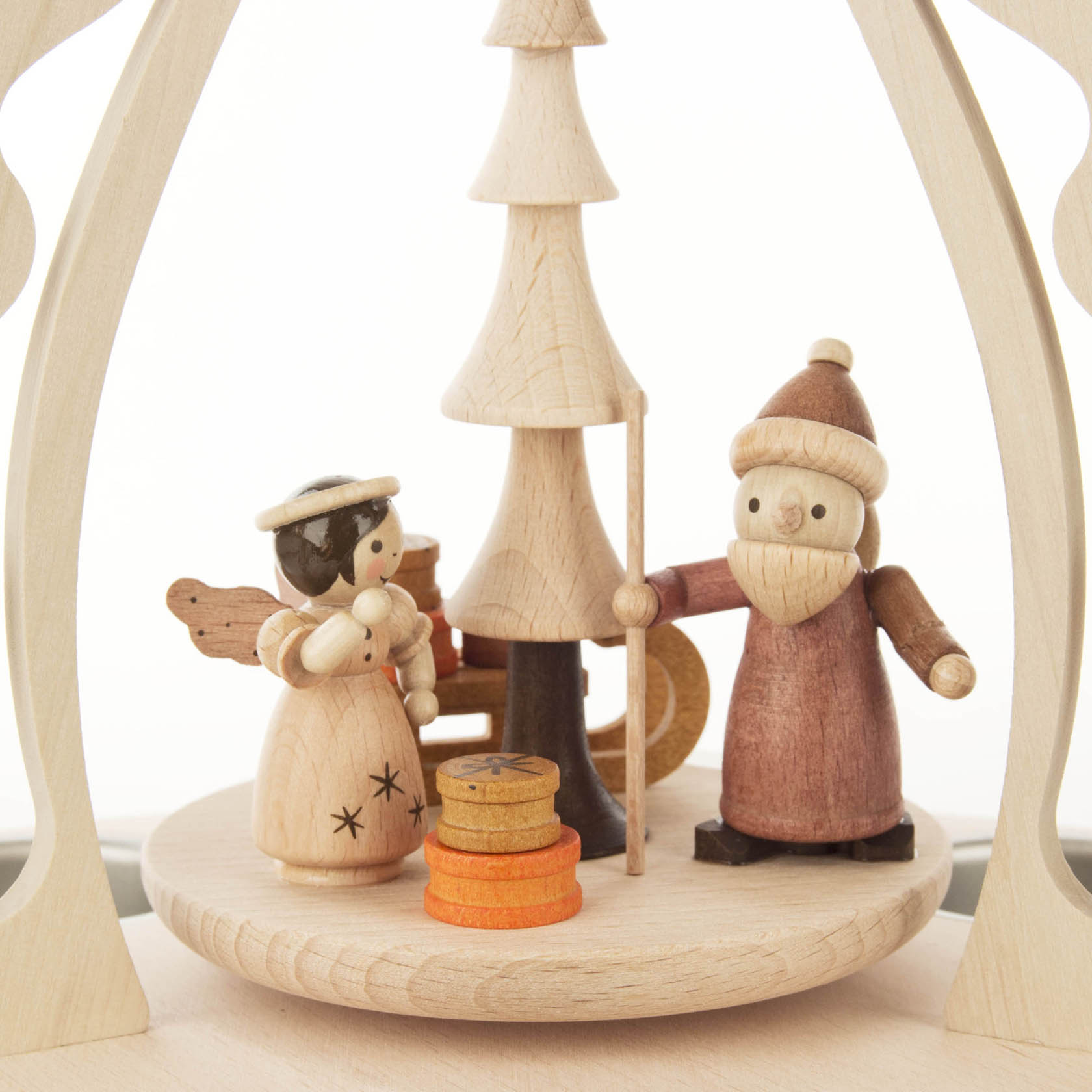 Holz-Weihnachtspyramide mit handgeschnitzter figurativer Szene: Engel mit Stern und Teddybär im Arm und Weihnachtsmann mit Stab, beide um einen Baum stehend.