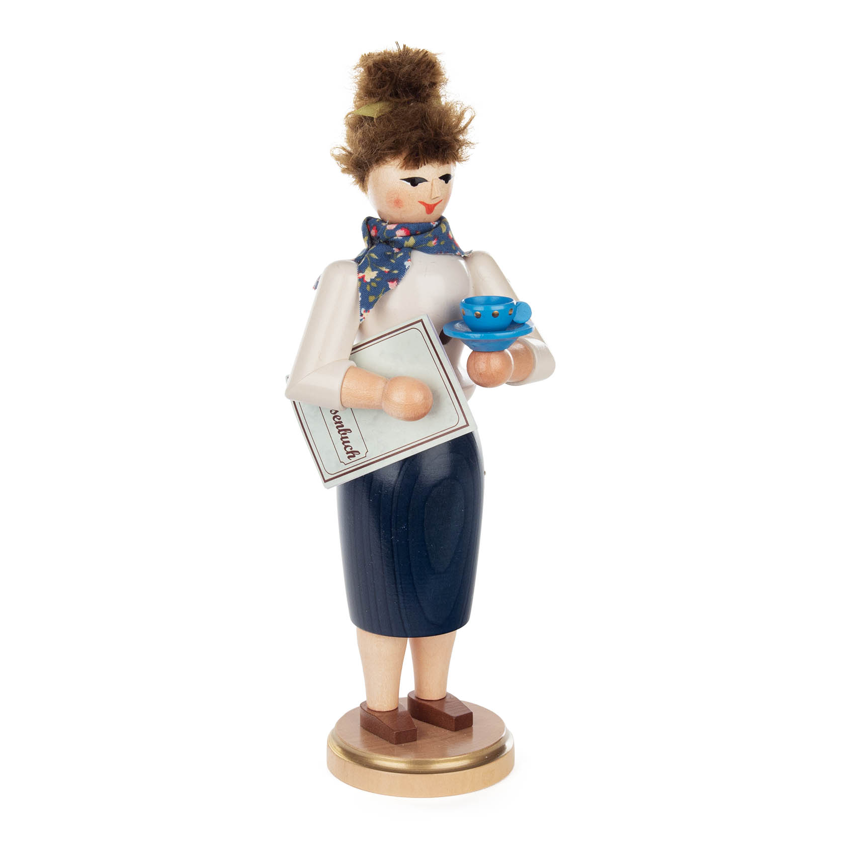 Räucherfigur einer Lehrerin mit dunklen Haaren. Sie hält ein Buch mit der Aufschrift 1x1 und eine blaue Tasse in den Händen. Trägt Rock und bluse. im Dregeno Online Shop günstig kaufen