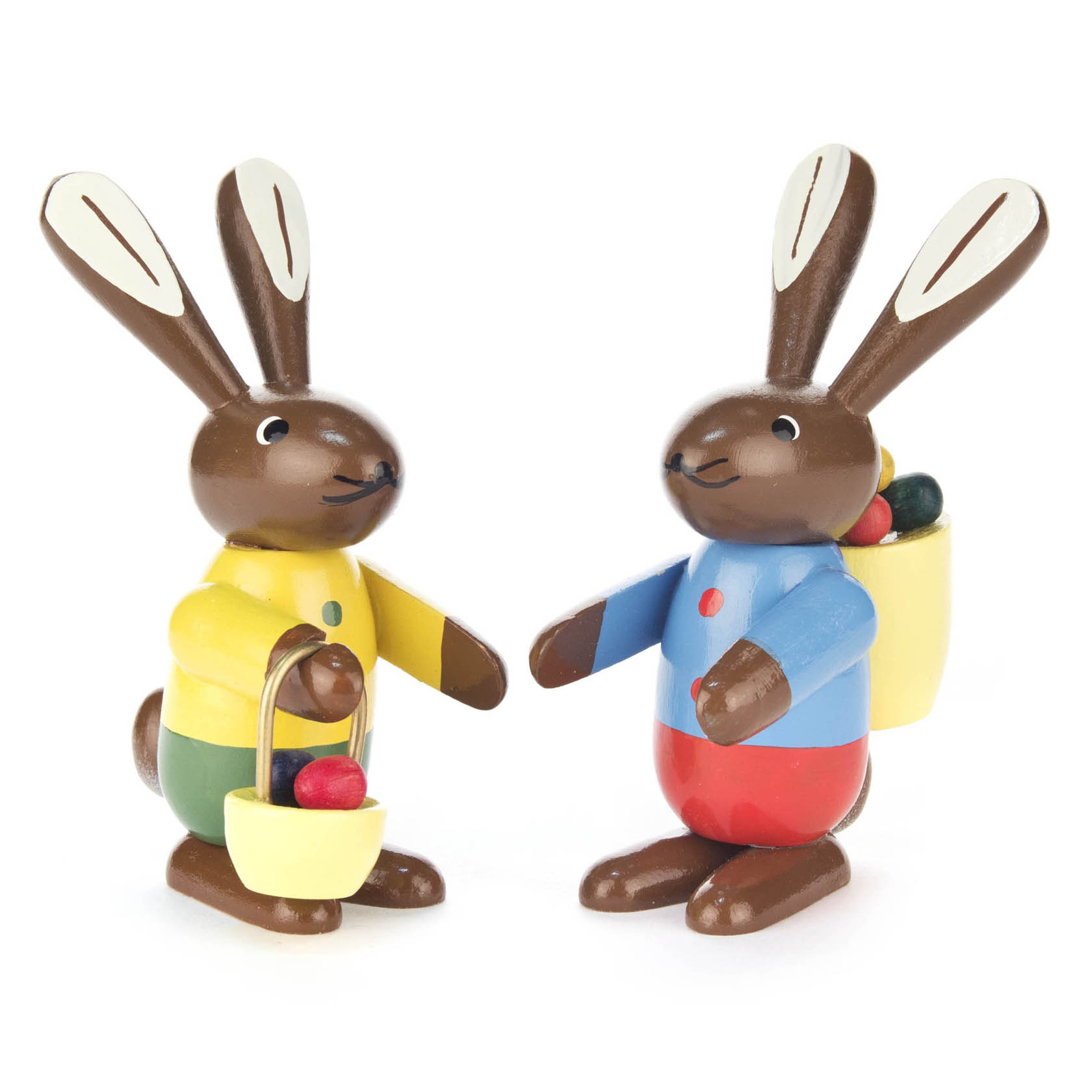 Zwei stilisierte Hasenfiguren mit langen Ohren. Ein Hase trägt gelbe Kleidung und hält einen Korb mit bunten Eiern. Der andere Hase trägt blaue Kleidung mit einem Korb auf dem Rücken. im Dregeno Online Shop günstig kaufen