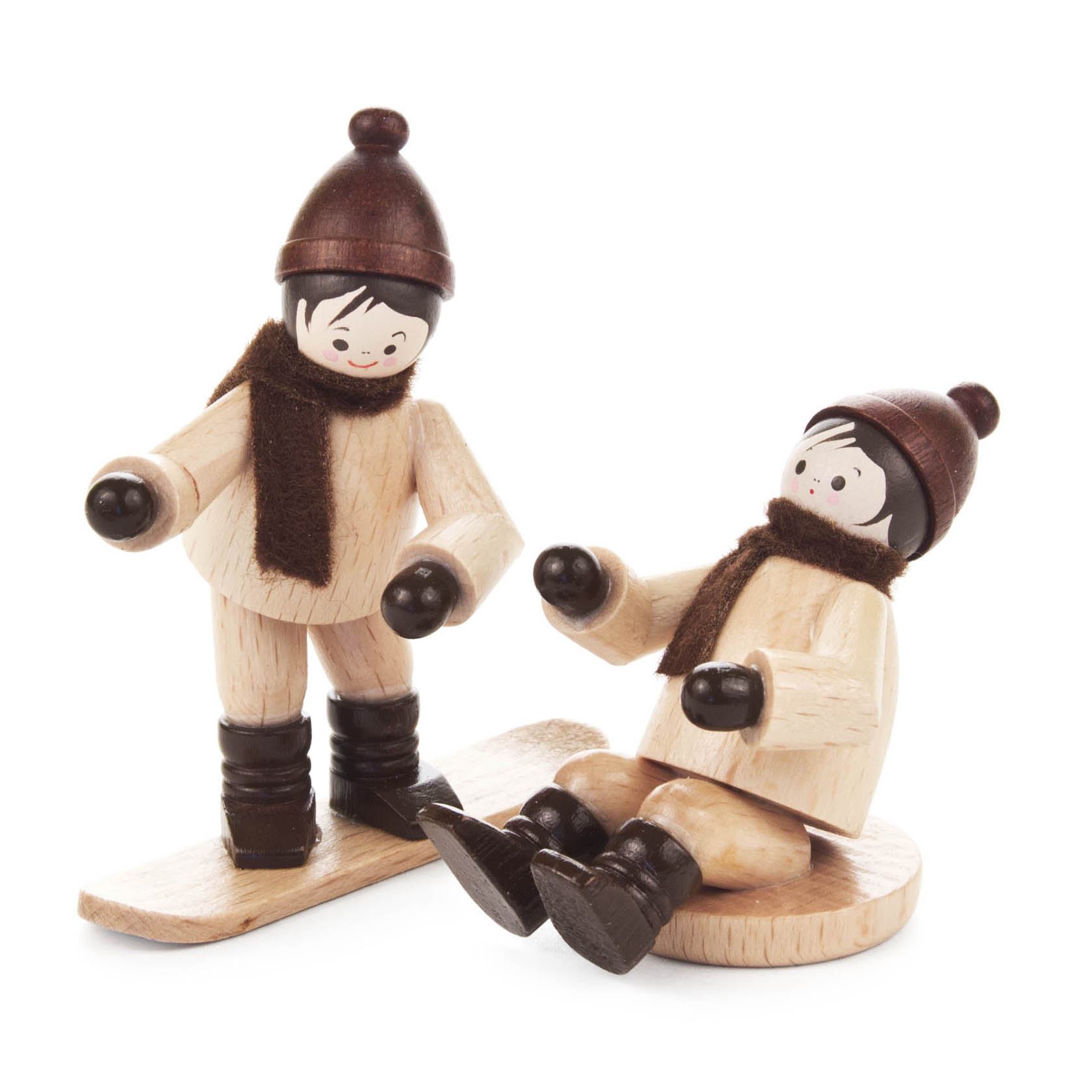 Holzfiguren von zwei Kindern: eins auf einem Snowboard, das andere auf einem Rutscher sitzend, beide in winterlicher Kleidung mit Mütze und Schal. im Dregeno Online Shop günstig kaufen