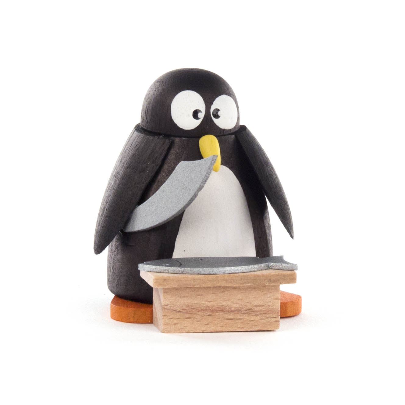 Kleiner Pinguin aus Holz steht hinter einem Holzstand und hält einen Fisch mit seinen Flügeln. im Dregeno Online Shop günstig kaufen