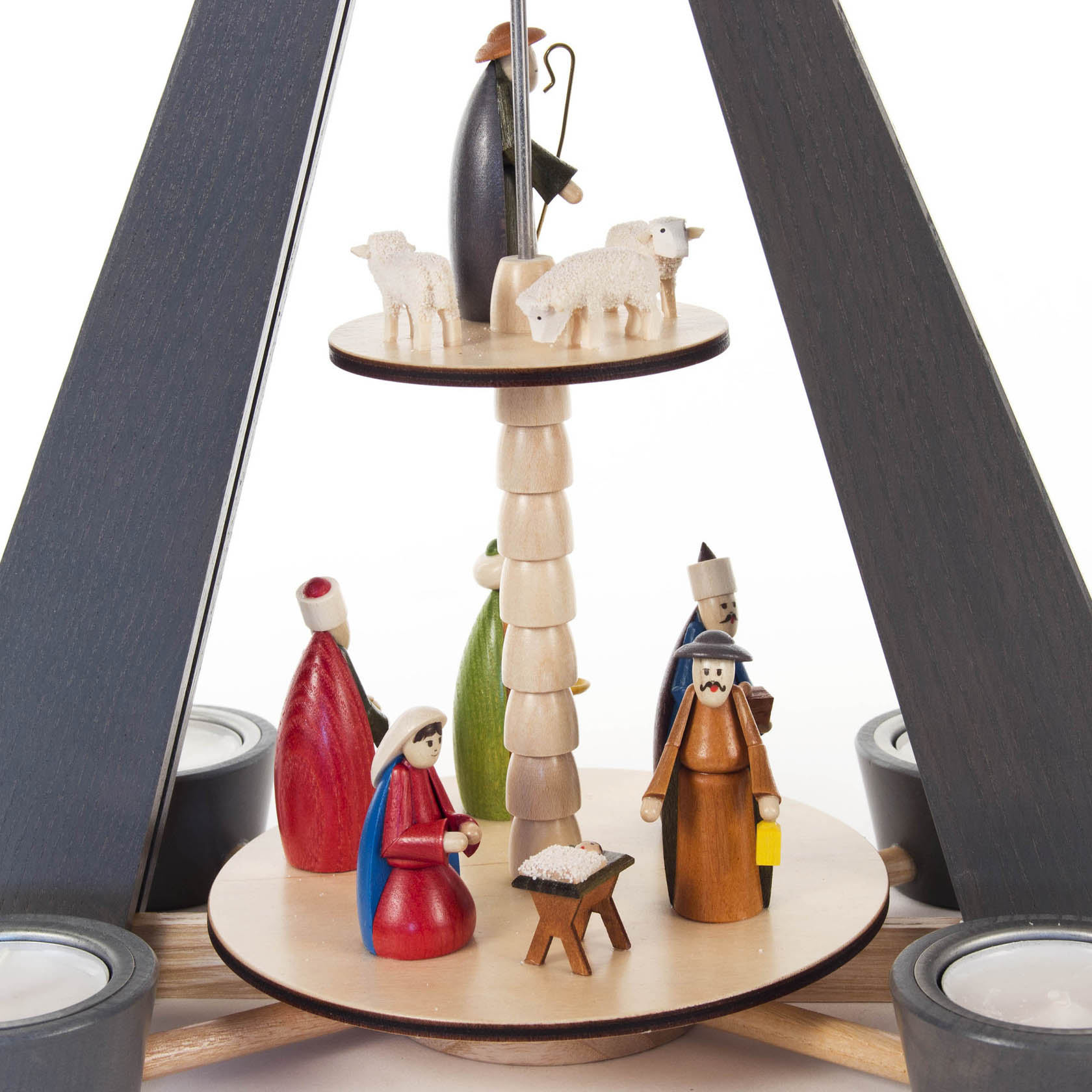 A two-tier pyramid featuring the nativity scene, with colorful wooden figures of Mary, Joseph, shepherds, and sheep. Designed for tealights.