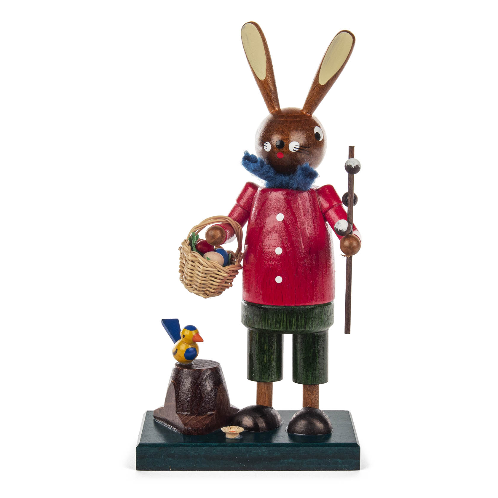 Eine Holzfigur des Osterhasen in rotem Hemd, grünen Hosen und blauem Schal. Der Hase hält einen Spazierstock und trägt einen Korb voller bunter Eier. im Dregeno Online Shop günstig kaufen