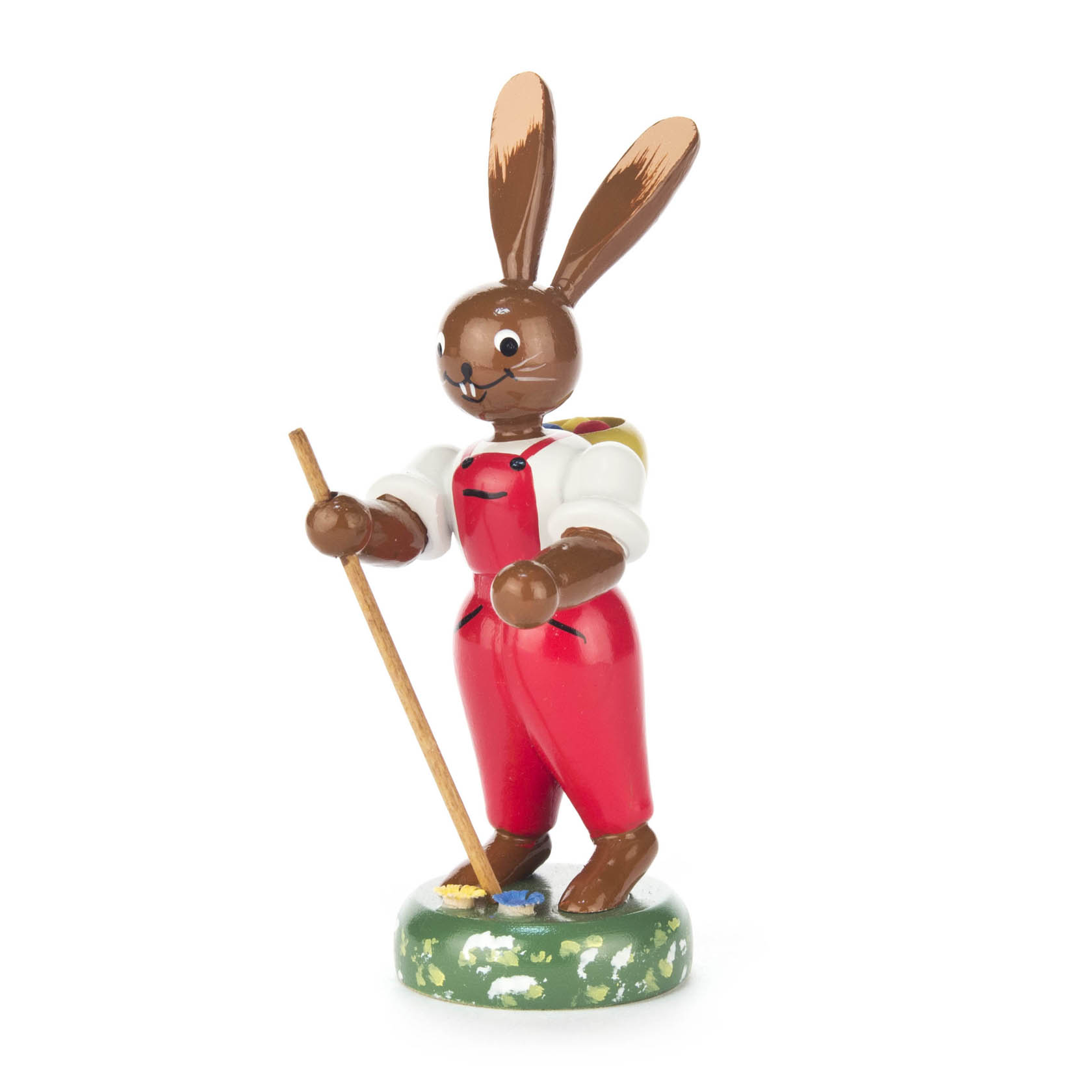 Holzfigur eines lachenden Hasen in roter Latzhose mit weißen Ärmeln. Hält einen Stock und trägt einen Tragekorb auf dem Rücken. im Dregeno Online Shop günstig kaufen