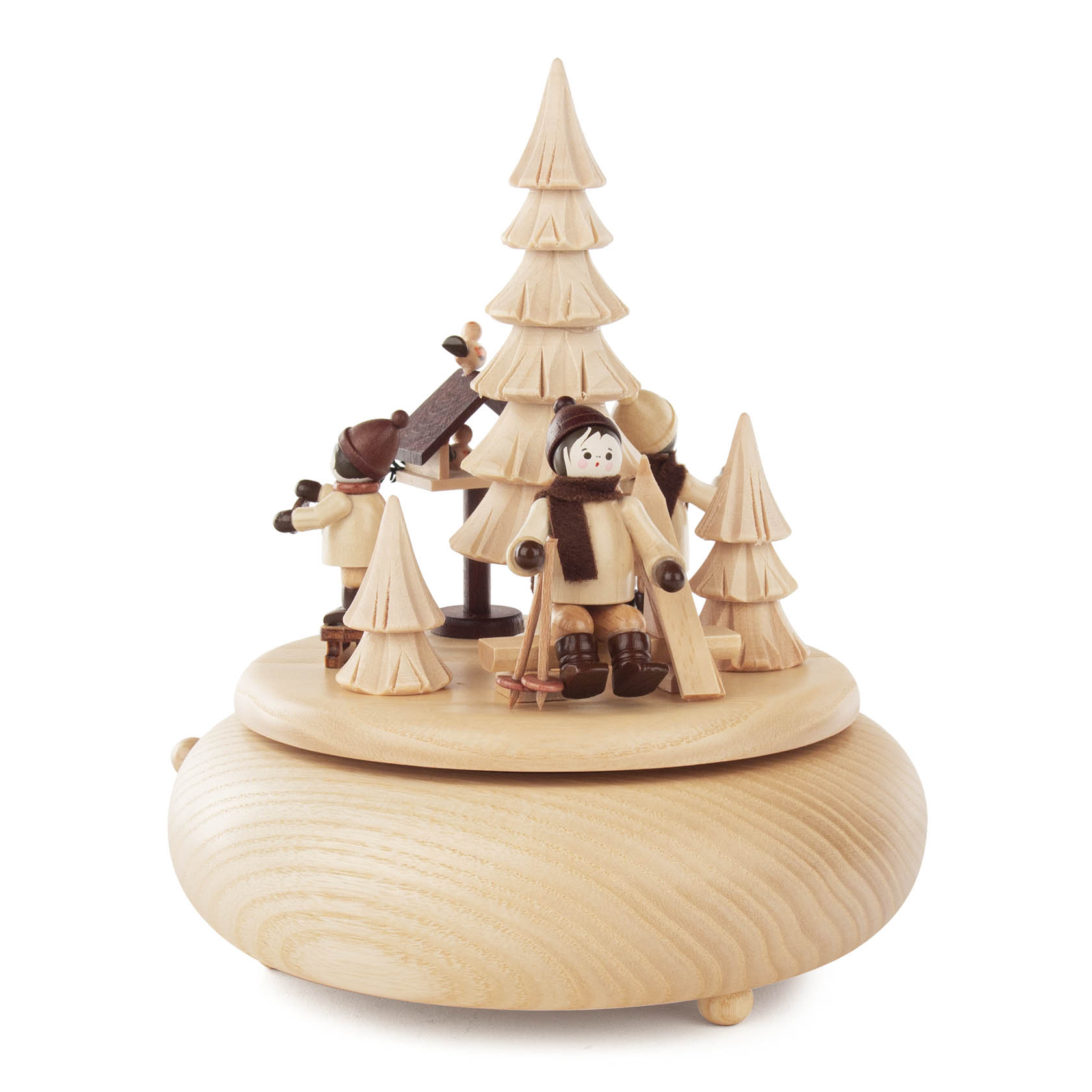 Holzspieldose mit Figuren, die ein Winterwaldszenario darstellen, inklusive eines Kindes mit Skiern, weiteren Figuren und einem zentralen Tannenbaum.