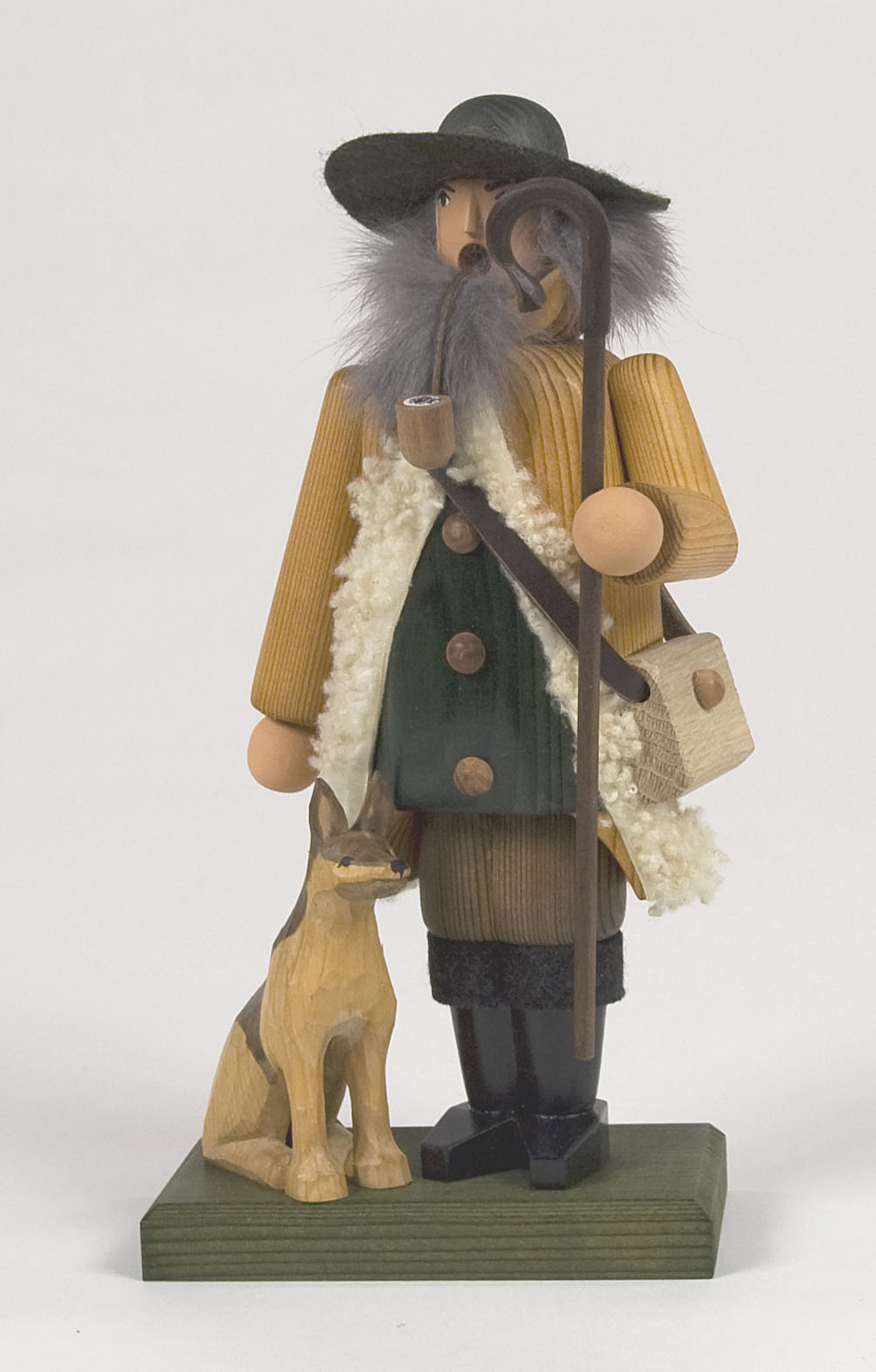 Holzfigur eines Schäfers mit grauem Bart, grünen Hut, gelbem Mantel und einem Schäferstab, steht neben einem Hund. im Dregeno Online Shop günstig kaufen