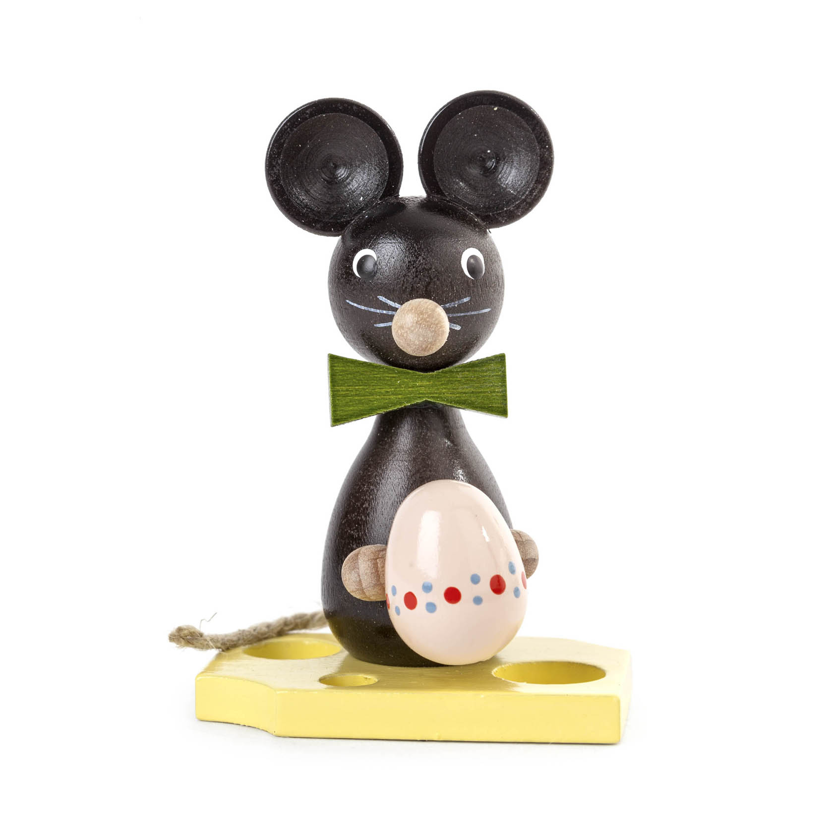 Eine hölzerne, schwarz-braune Maus mit großen, runden Ohren, grüner Fliege und einem bemalten Ei steht auf einem gelben Stück Käse. im Dregeno Online Shop günstig kaufen