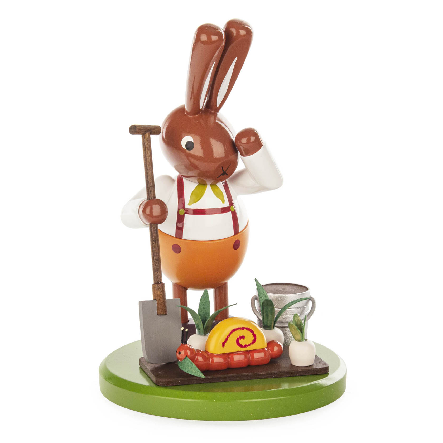 Eine bemalte Figur eines Hasen in Arbeitskleidung, der in einem Rübenfeld mit einem Spaten steht und eine Schnecke auf einer roten Schale betrachtet. im Dregeno Online Shop günstig kaufen
