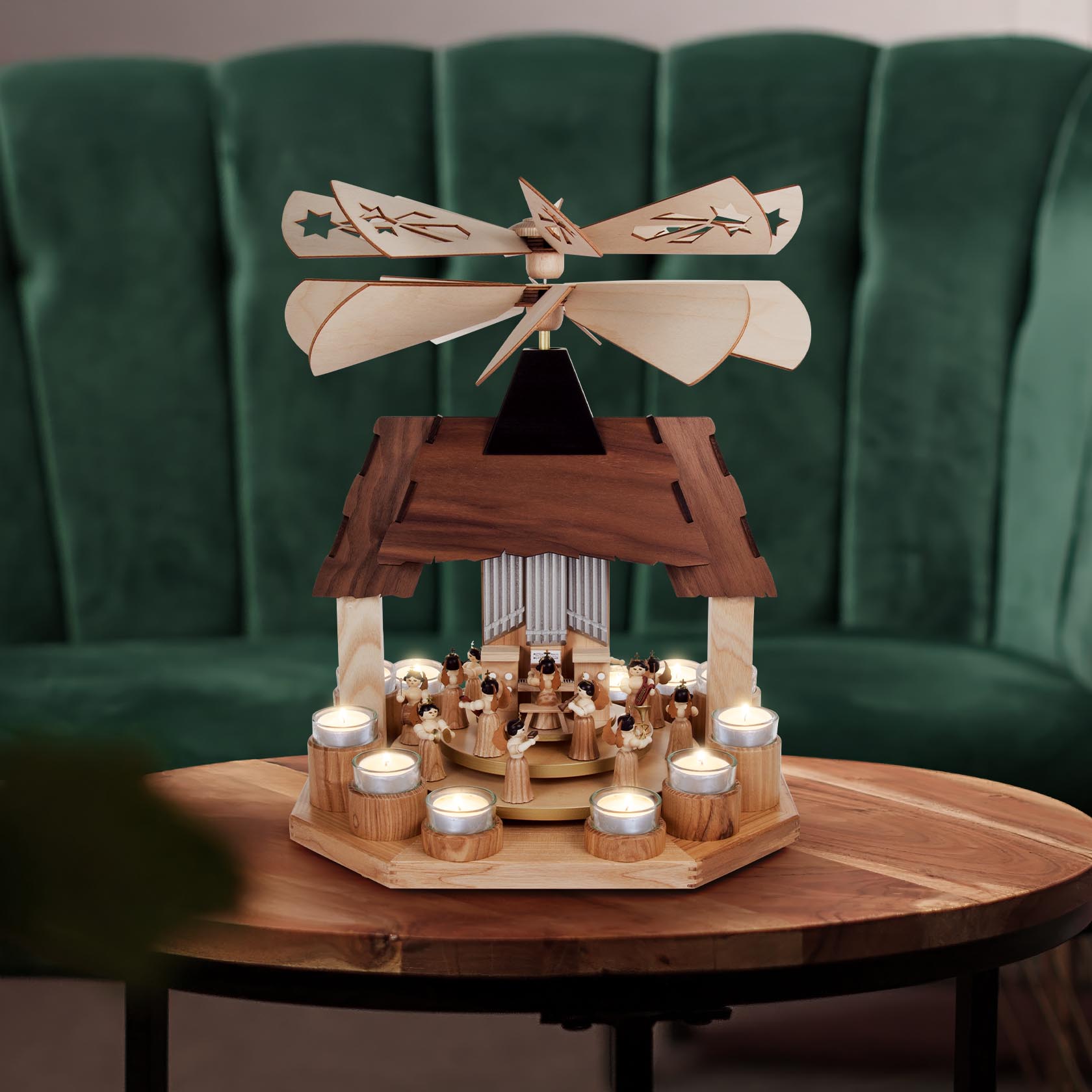 Weihnachtspyramide mit mehreren Engelfiguren, zwei Drehteller und zwei Flügelräder, umgeben von sechs brennenden Teelichtern.