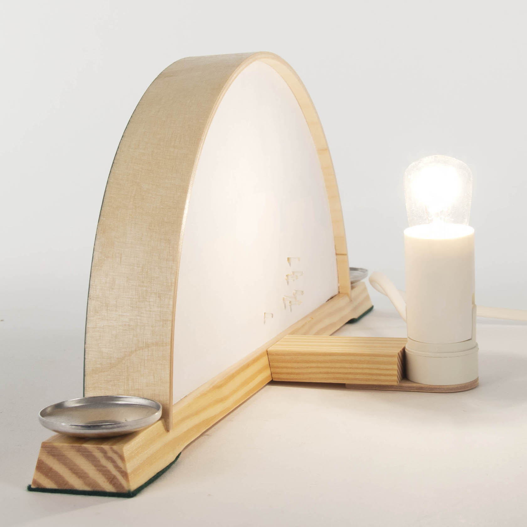 Holzbogen mit geschwungener Form, elektrischer Lampe auf der rechten Seite und Sockelunterlage.