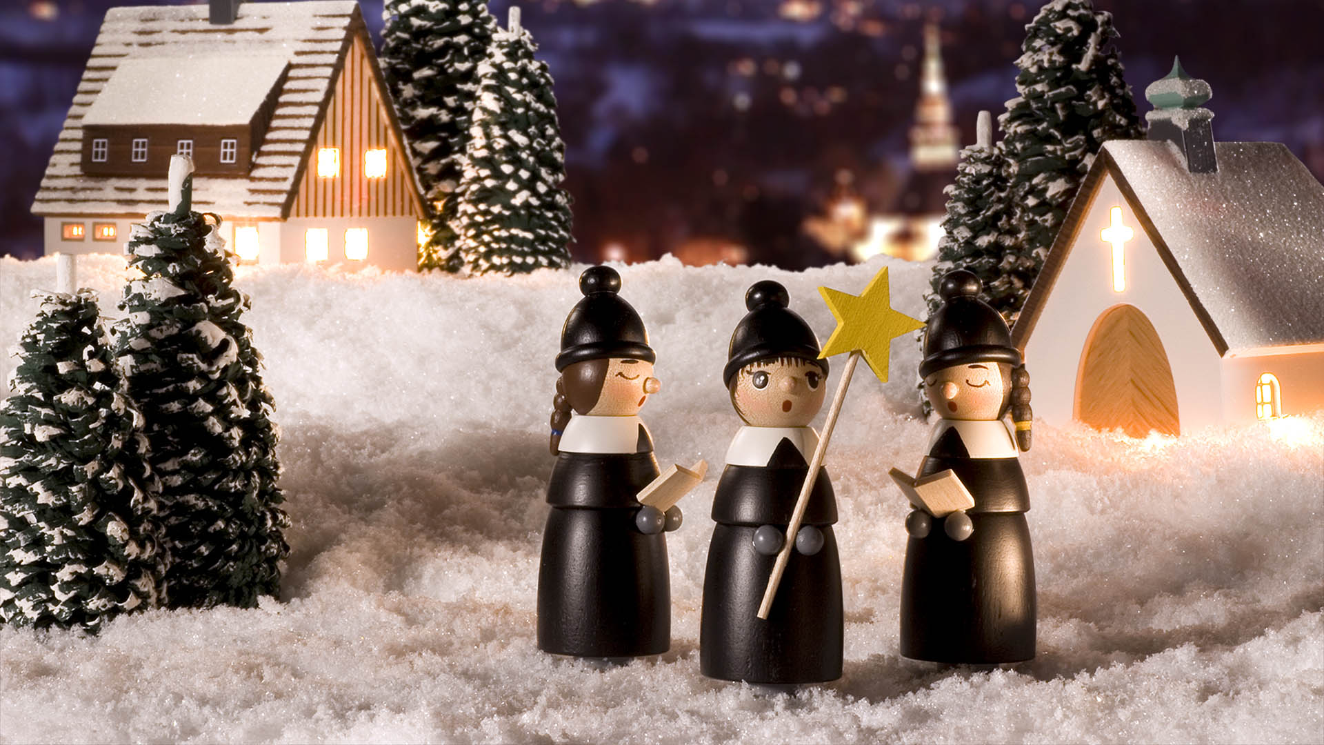 Kurrendefiguren vor winterlichem Dorf