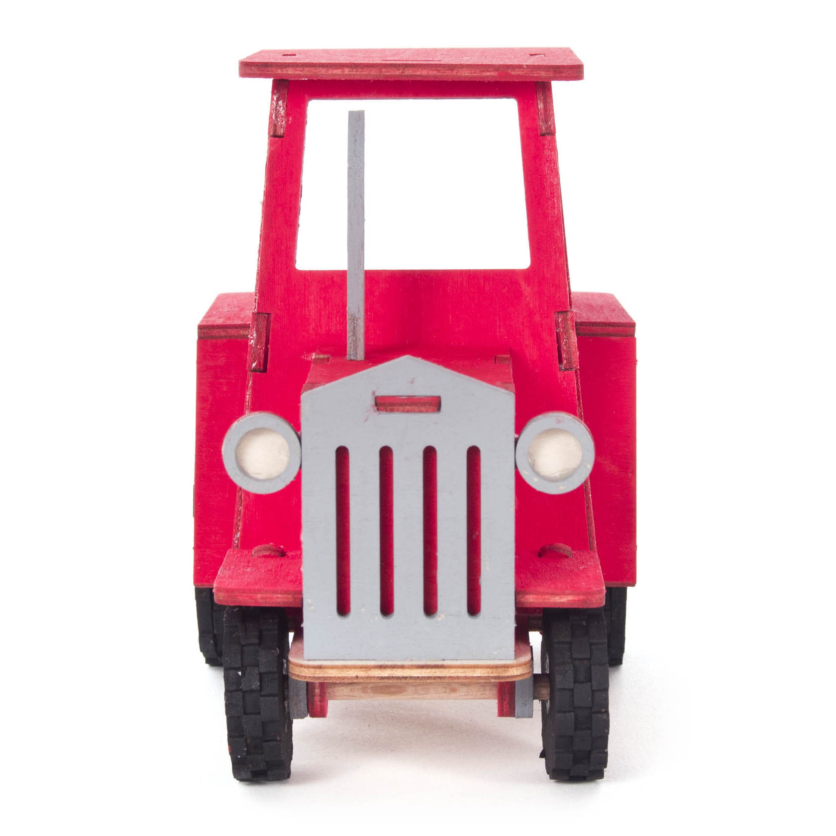 A small red toy tractor model with a simplistic design, featuring a flat rectangular top, circular headlights, and black wheels on a white background.