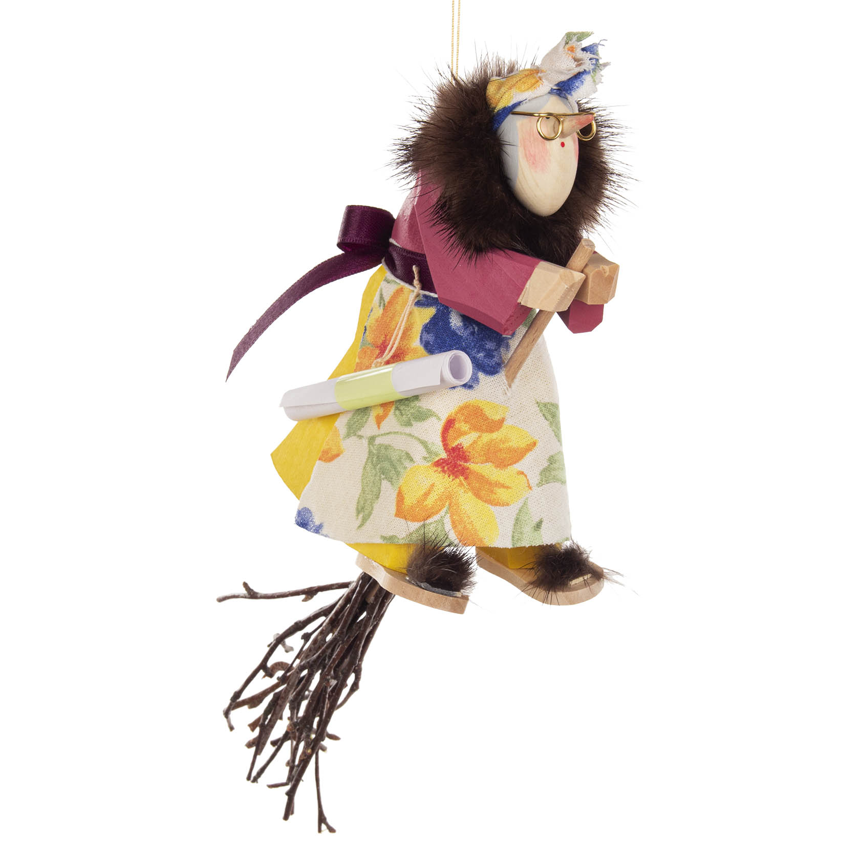 Eine geschnitzte Hexenfigur mit Brille, Spinne, buntem Kleid und Pelzmantel sitzt auf einem Besen. Die Hexe ist zum Aufhängen geeignet. im Dregeno Online Shop günstig kaufen