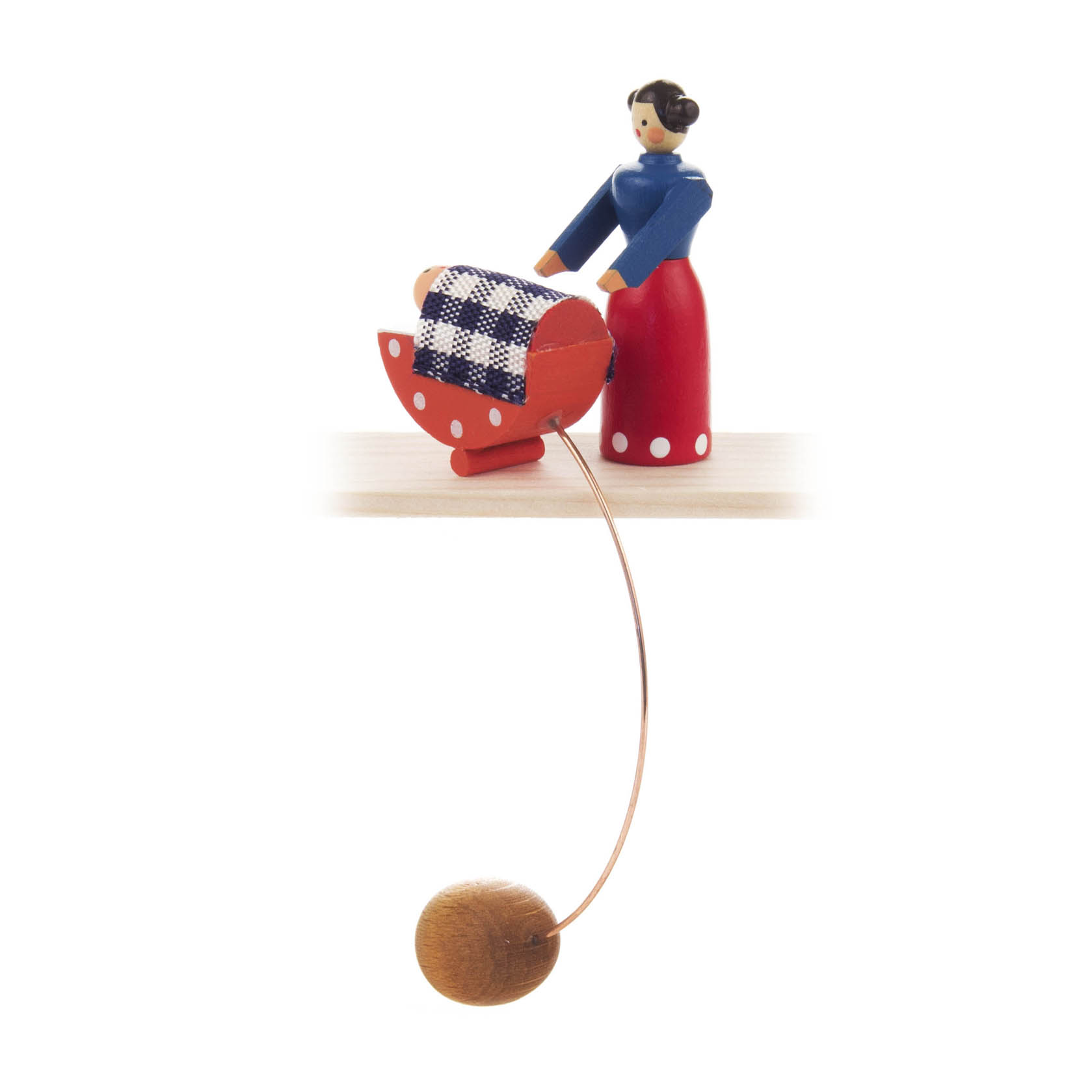 Holzfigur einer Frau in blauem Oberteil und rotem Rock, die eine rot-weiß karierte Wiege schaukelt. Die Figur steht auf einem Sockel mit Gegengewicht. im Dregeno Online Shop günstig kaufen