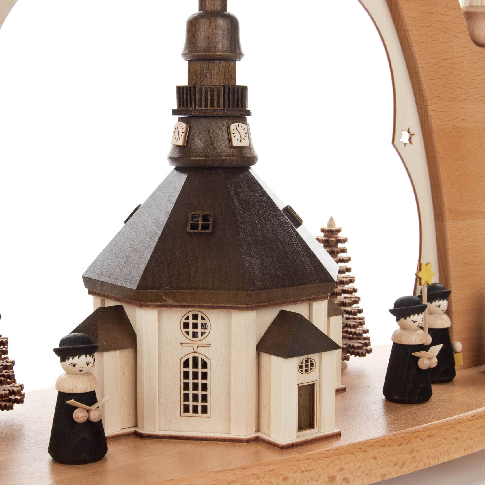 Carved wooden arch featuring the Seiffen Church in the center, surrounded by small wooden choir figures and illuminated from within.