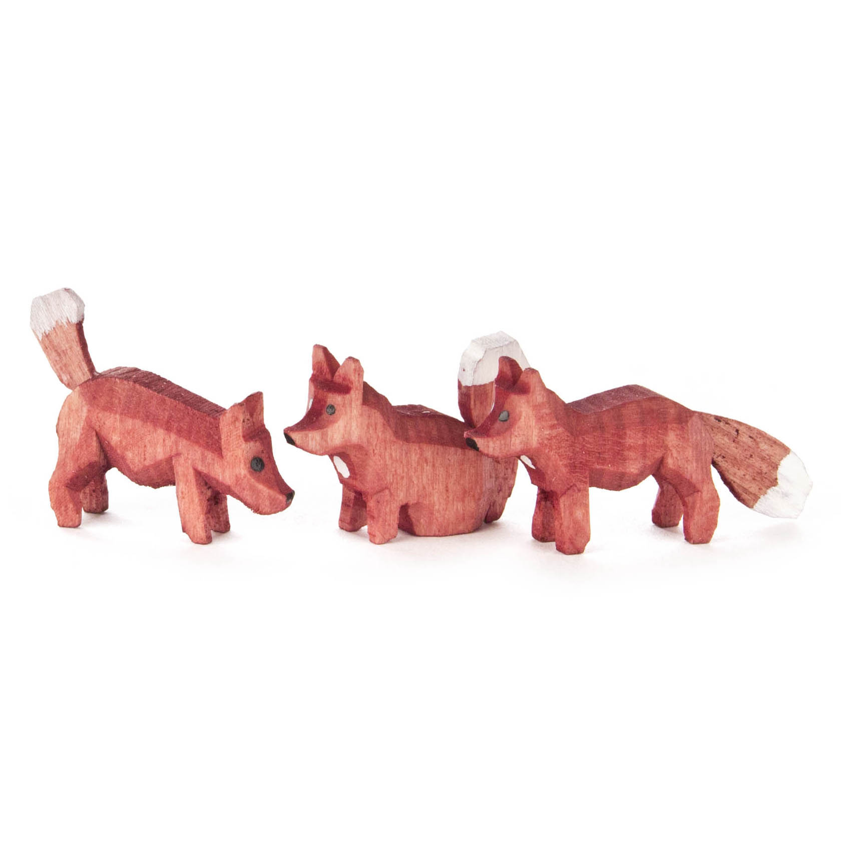 Drei handgeschnitzte, farbige Holzfüchse in verschiedenen Posen: stehend, sitzend und fauchend. Jeder Fuchs hat eine Rückenhöhe von 1,5 cm. im Dregeno Online Shop günstig kaufen