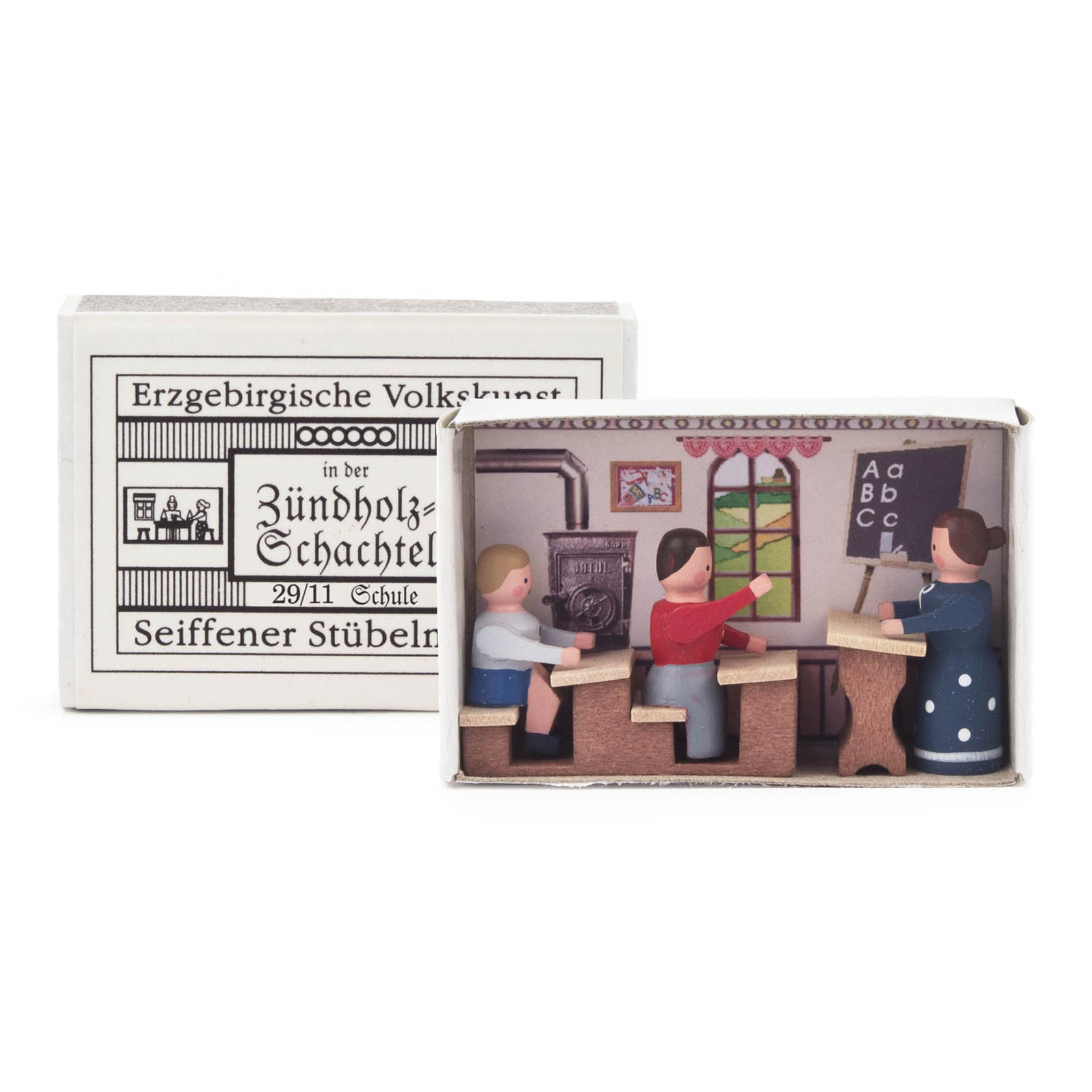 Miniatur-Schulzimmer in einer Streichholzschachtel, mit drei Figuren: einem Lehrer an der Tafel und zwei Schülern an Bänken. im Dregeno Online Shop günstig kaufen