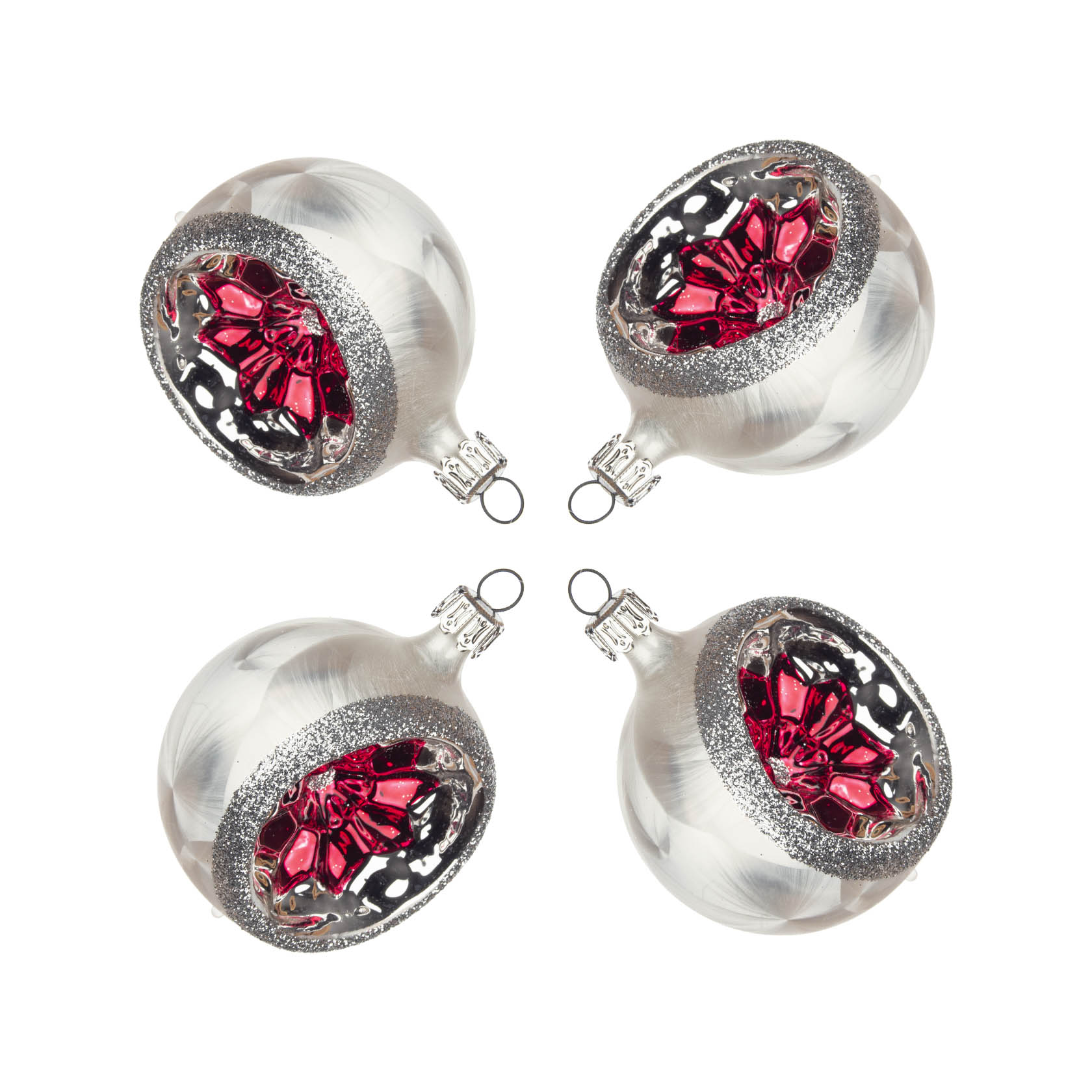 Vier eisweiße, runde Christbaumkugeln mit rotem Reflexzentrum und silbernem Glitzerrand, die in einem Quadrat angeordnet sind. im Dregeno Online Shop günstig kaufen