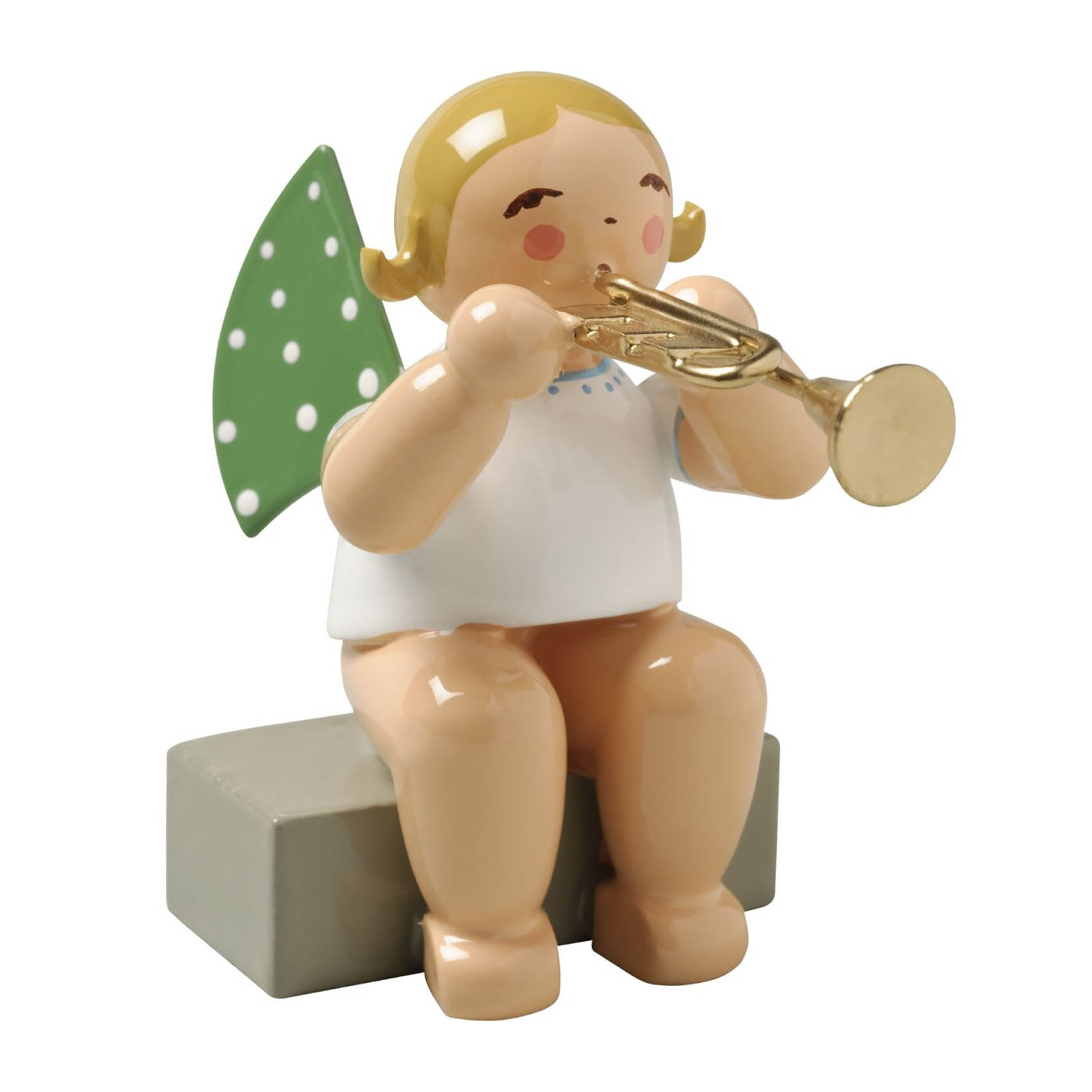 Holzfigur eines sitzenden Engels mit grünen Flügeln, der eine Trompete spielt. Der Engel hat blonde Haare und sitzt auf einem grauen Sockel. im Dregeno Online Shop günstig kaufen