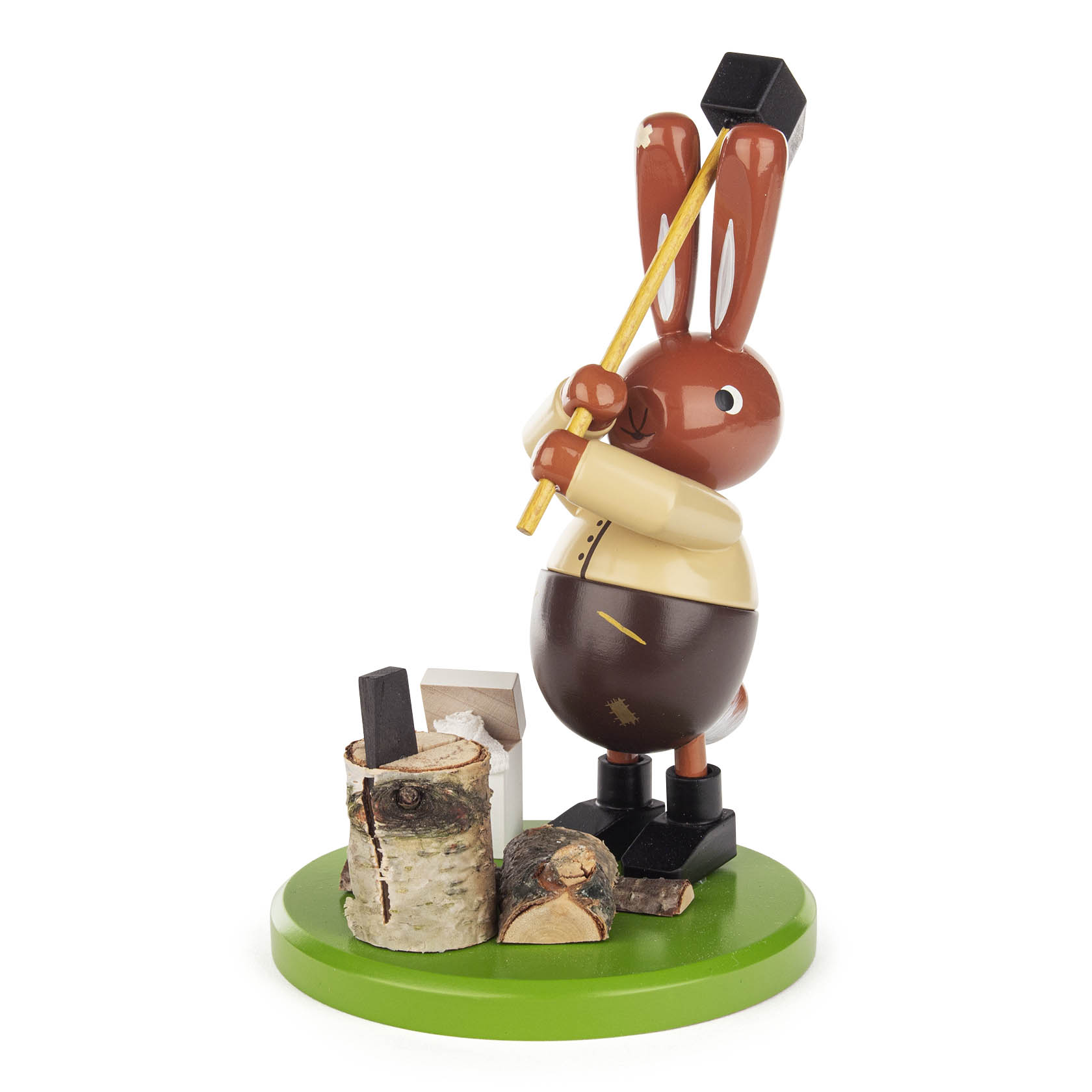 Eine hölzerne Figur eines Hasen in traditioneller Kleidung, der mit einer schwarzen Axt auf einen Holzklotz schlägt. Der Hase steht auf einem grünen Sockel. im Dregeno Online Shop günstig kaufen