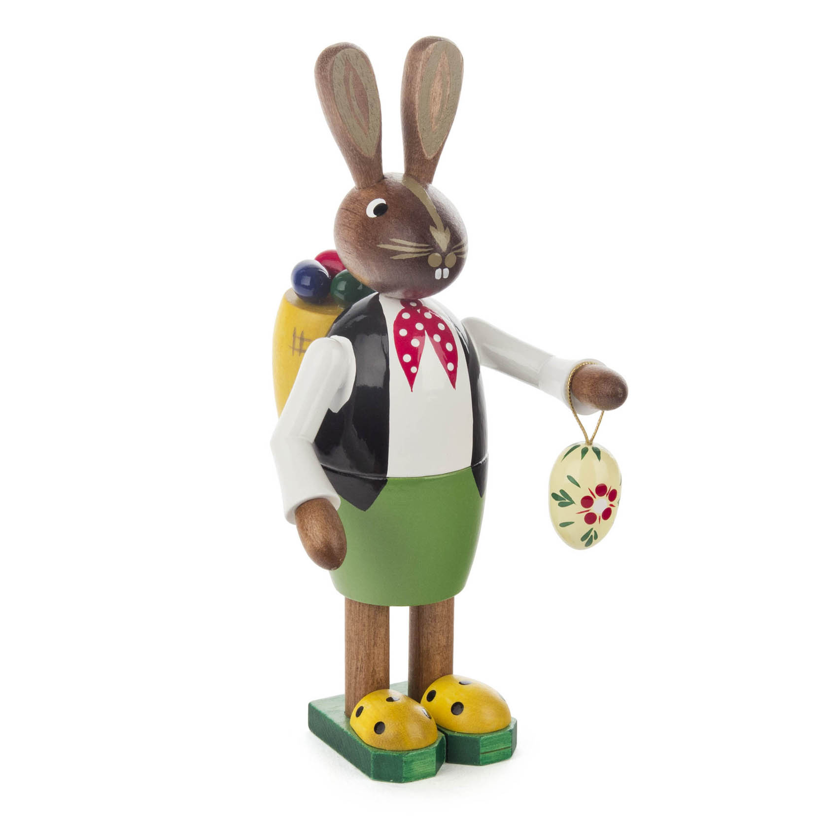 Holzfigur eines Osterhasenmannes, 14 cm groß, mit grünem Unterteil und schwarzer Weste. Er hält ein kleines, bemaltes Osterei und hat einen Korb auf dem Rücken. im Dregeno Online Shop günstig kaufen