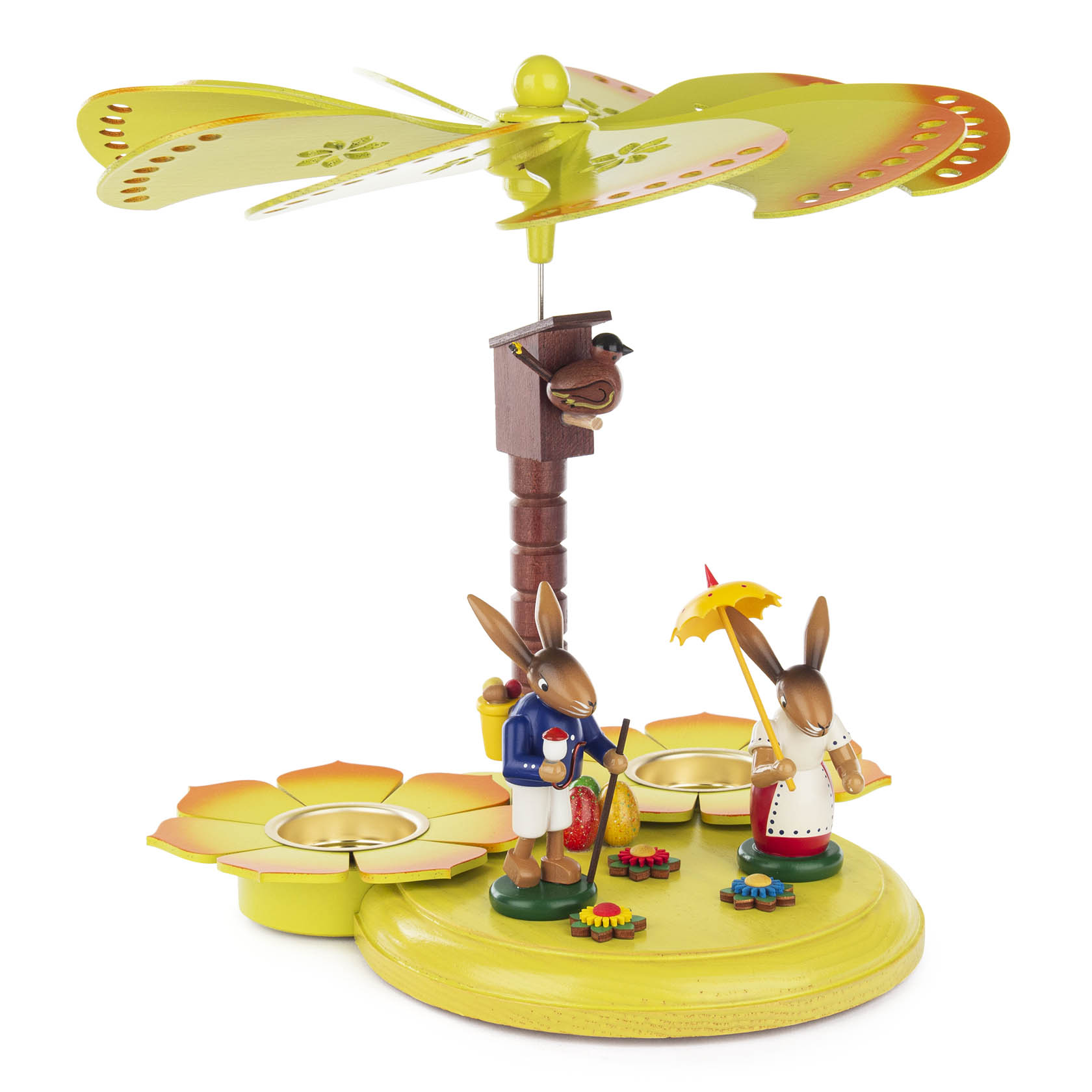Bunte Teelichtpyramide mit zwei Hasenfiguren; ein Hase trägt einen Schirm und eine Kiepe, der andere ein Tablett. Die Pyramide hat einen Blumenrotor. im Dregeno Online Shop günstig kaufen