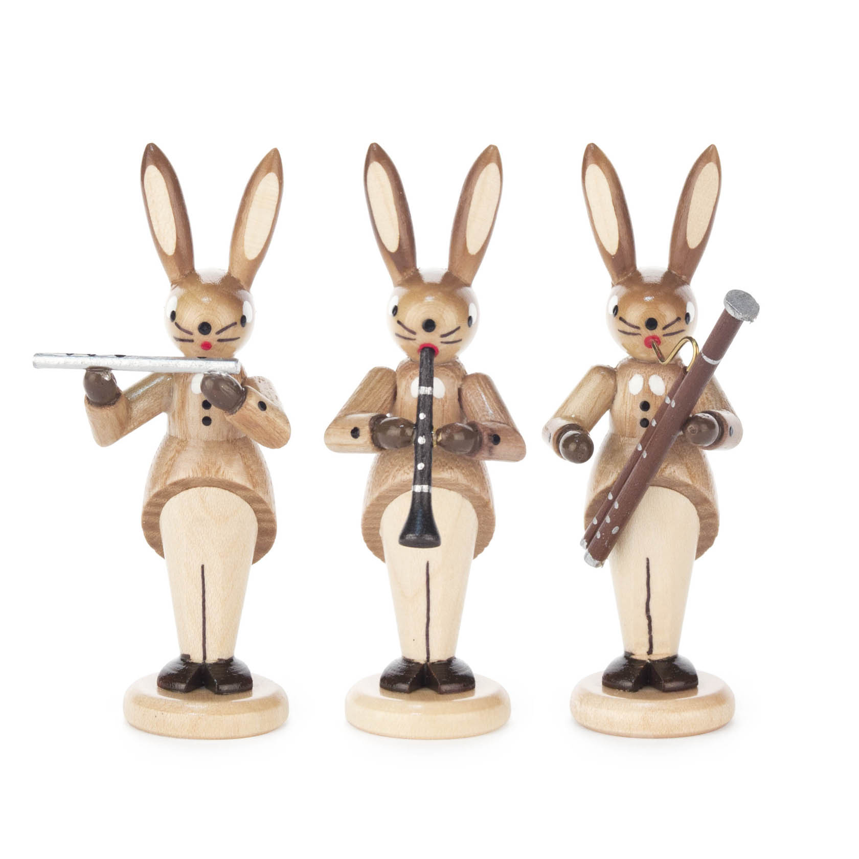 Drei hölzerne Hasenfiguren stehen nebeneinander. Jeder Hase hält ein Musikinstrument: Querflöte, Klarinette und Fagott. Die Hasen sind in Naturtönen bemalt. im Dregeno Online Shop günstig kaufen