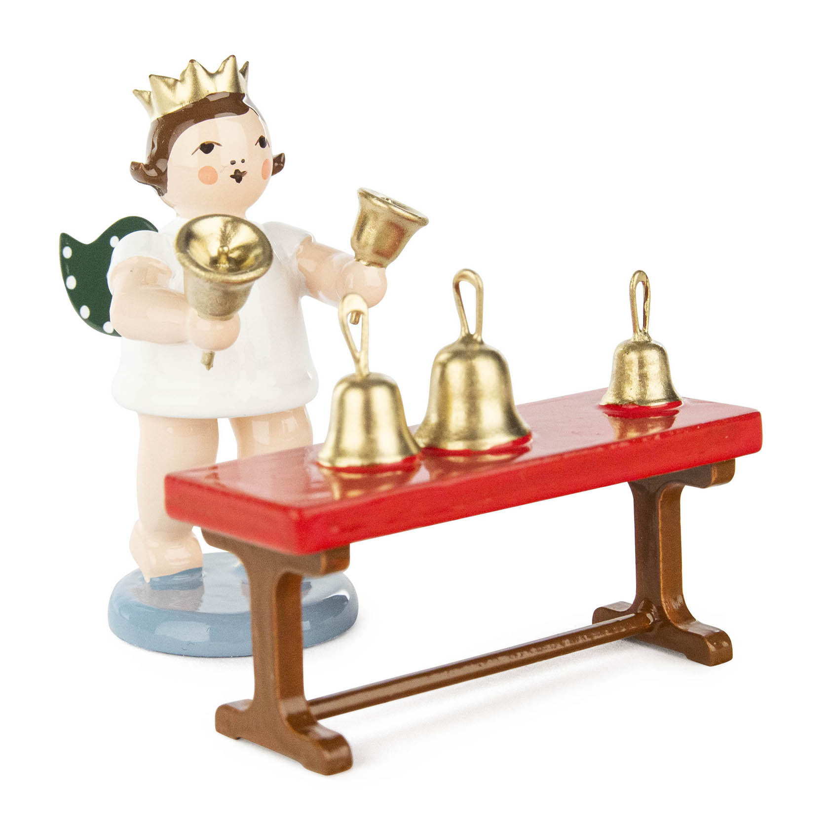Holzfigur eines Engels mit Krone, der ein Handglockenspiel mit einer Glocke in der Hand und drei auf einem roten Tisch stehendem Glocken spielt. im Dregeno Online Shop günstig kaufen