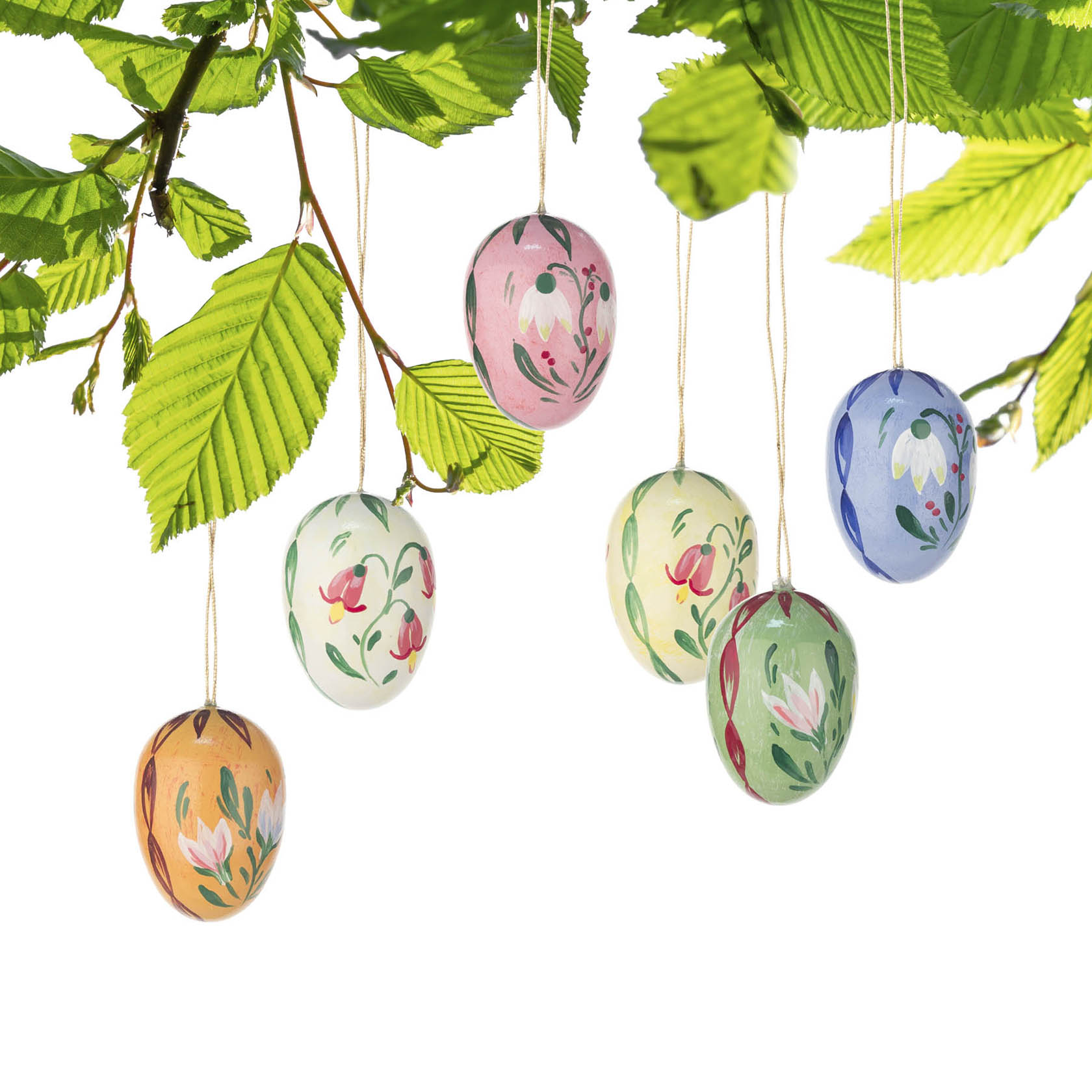 Sechs bunte, handbemalte Ostereier hängen an Zweigen mit grünen Blättern. Die Eier sind in verschiedenen Farben und mit floralen Mustern dekoriert.