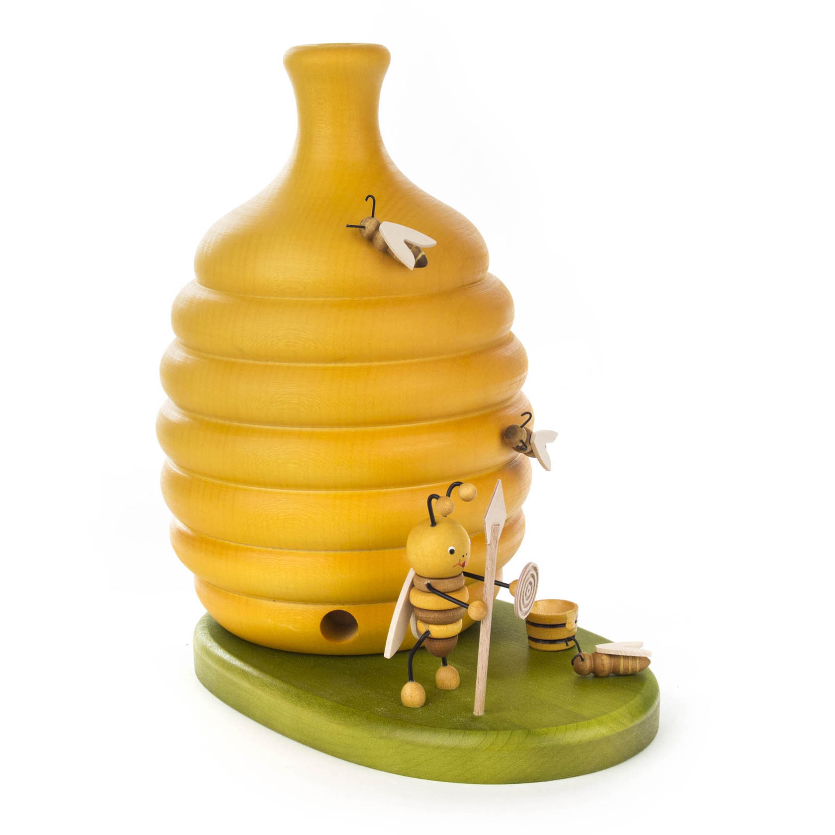 Dekorativer Bienenstock aus Holz mit Räucherfunktion, verziert mit Bienenfiguren und einer Biene, die mit Hut und Stab nahe eines kleinen Topfes steht.