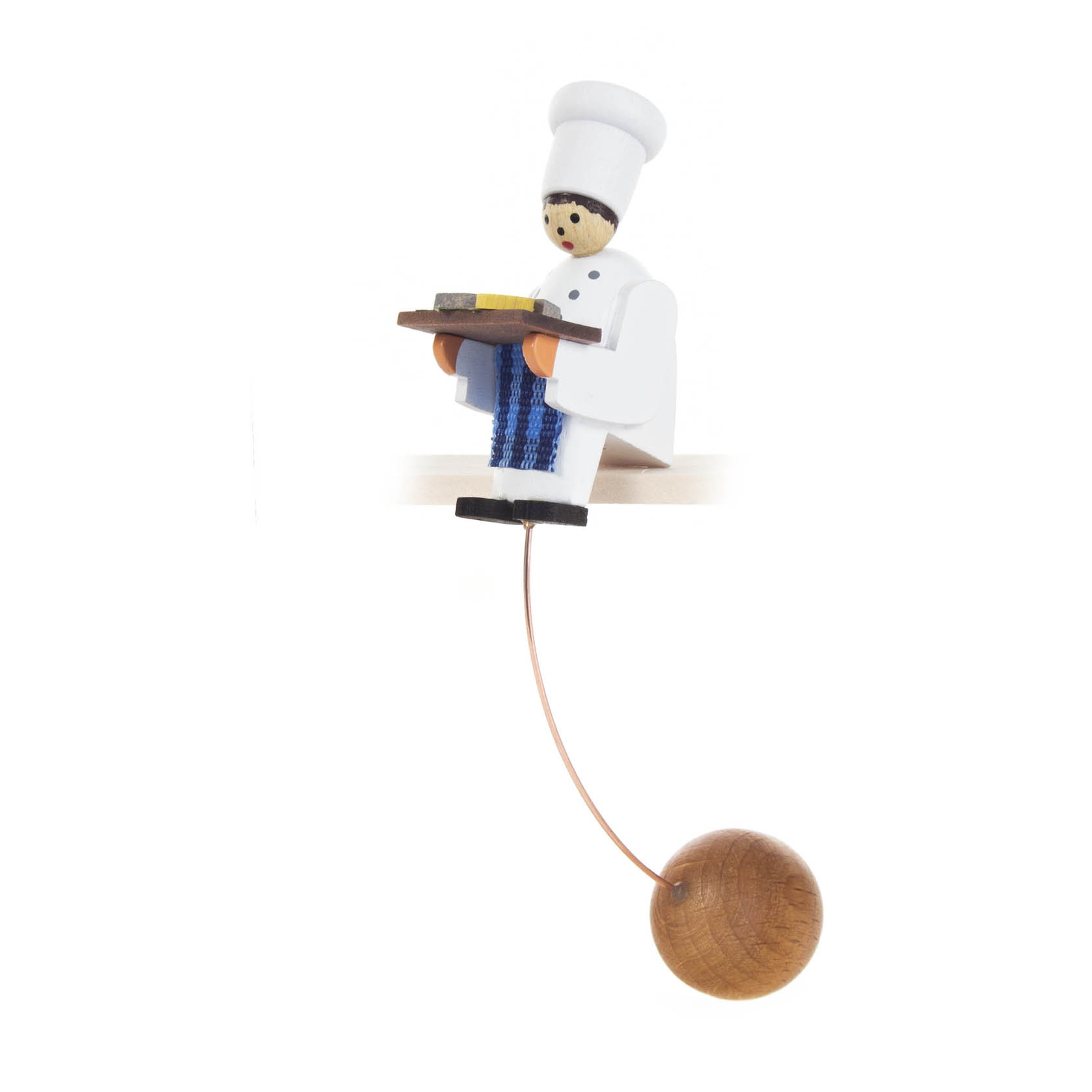 Eine Schaukelfigur eines Kochs in weißer Uniform und Mütze. Er hält ein Tablett mit Speisen und hängt an einem Draht mit Holzkugel als Gegengewicht. im Dregeno Online Shop günstig kaufen