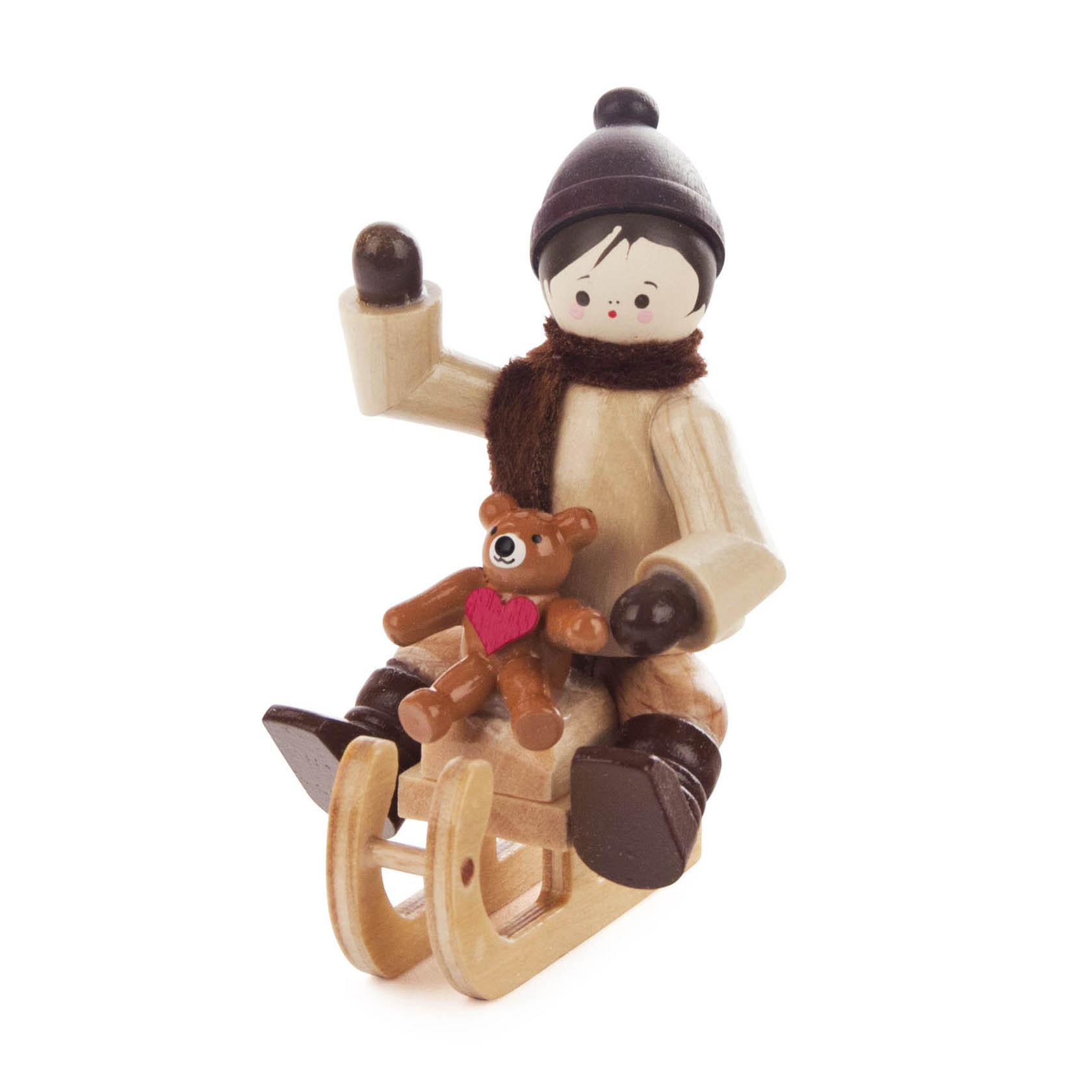Holzfigur eines Kindes im Winteroutfit mit Mütze und Schal, das einen Teddy mit Herz auf dem Schoß hält und auf einem Schlitten sitzt. im Dregeno Online Shop günstig kaufen