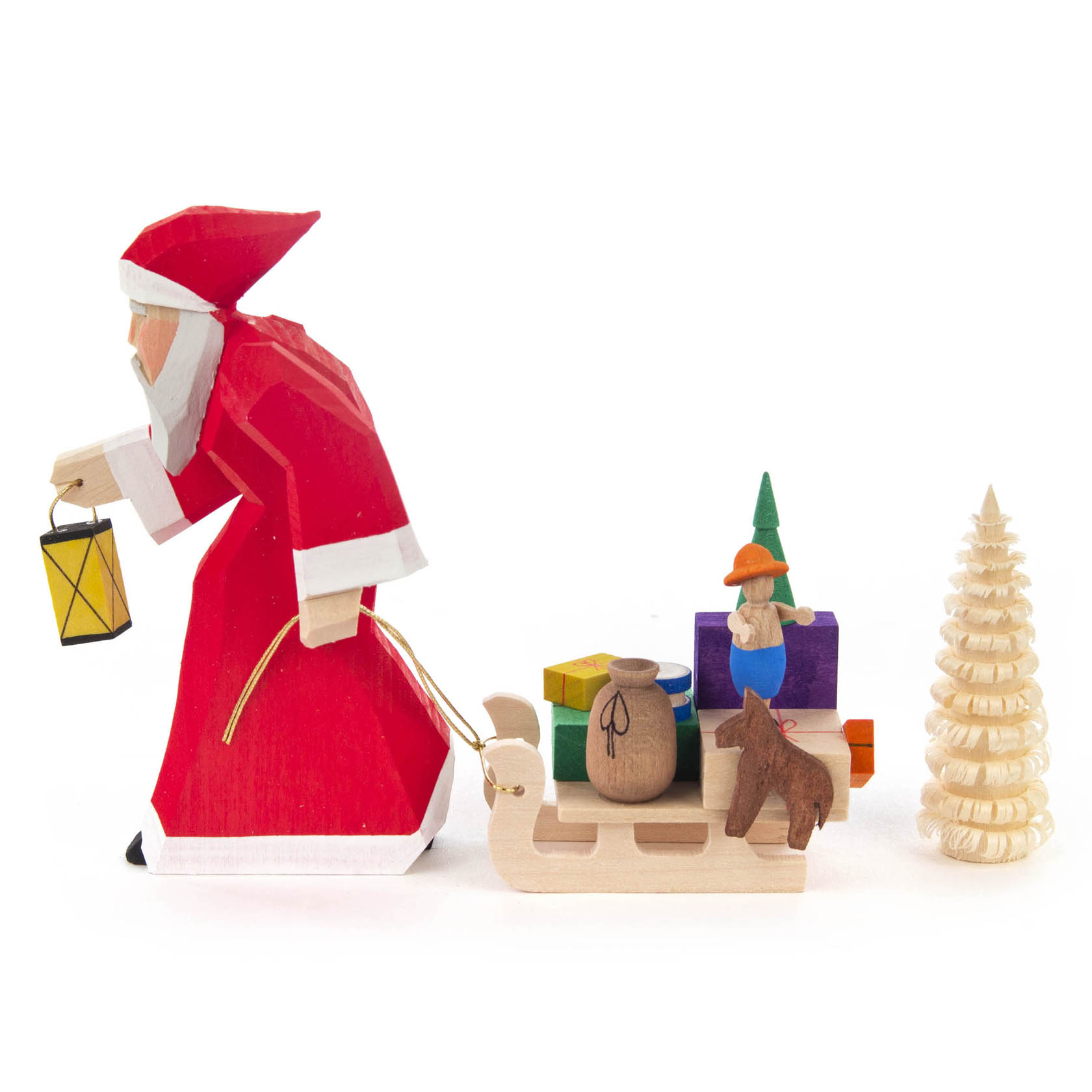 Holzfigur eines Weihnachtsmannes in rotem Anzug, der einen Schlitten mit Geschenken zieht. Daneben ein kleines geschnitztes Bäumchen.