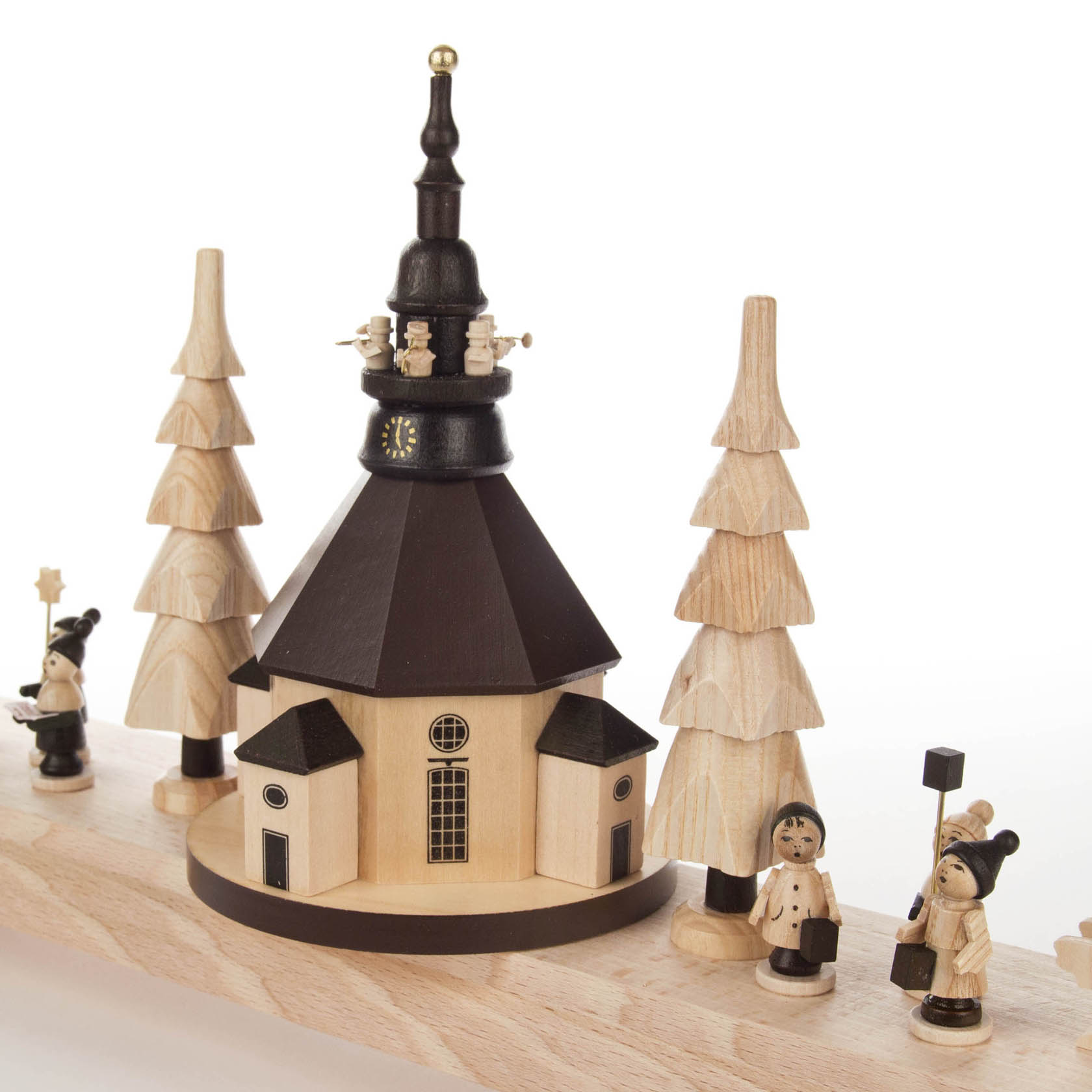 Holz-Schwibbogen mit Seiffener Kirche und drei handgeschnitzten Holzfiguren und Bäumen, beleuchtet durch LED-Lichter.