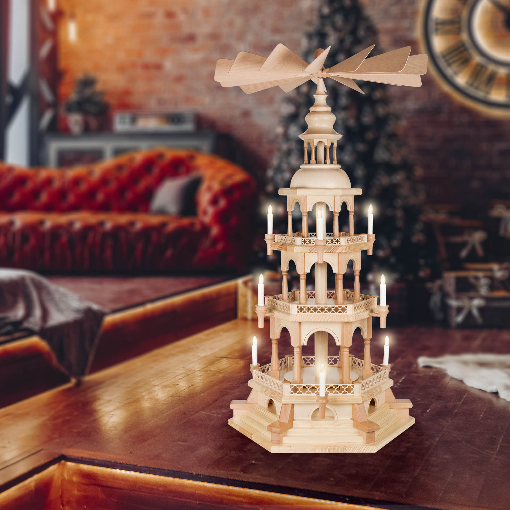 A three-tiered wooden Christmas pyramid with electric candles and a fan on top. The pyramid is intricately designed with arches and miniature figures.