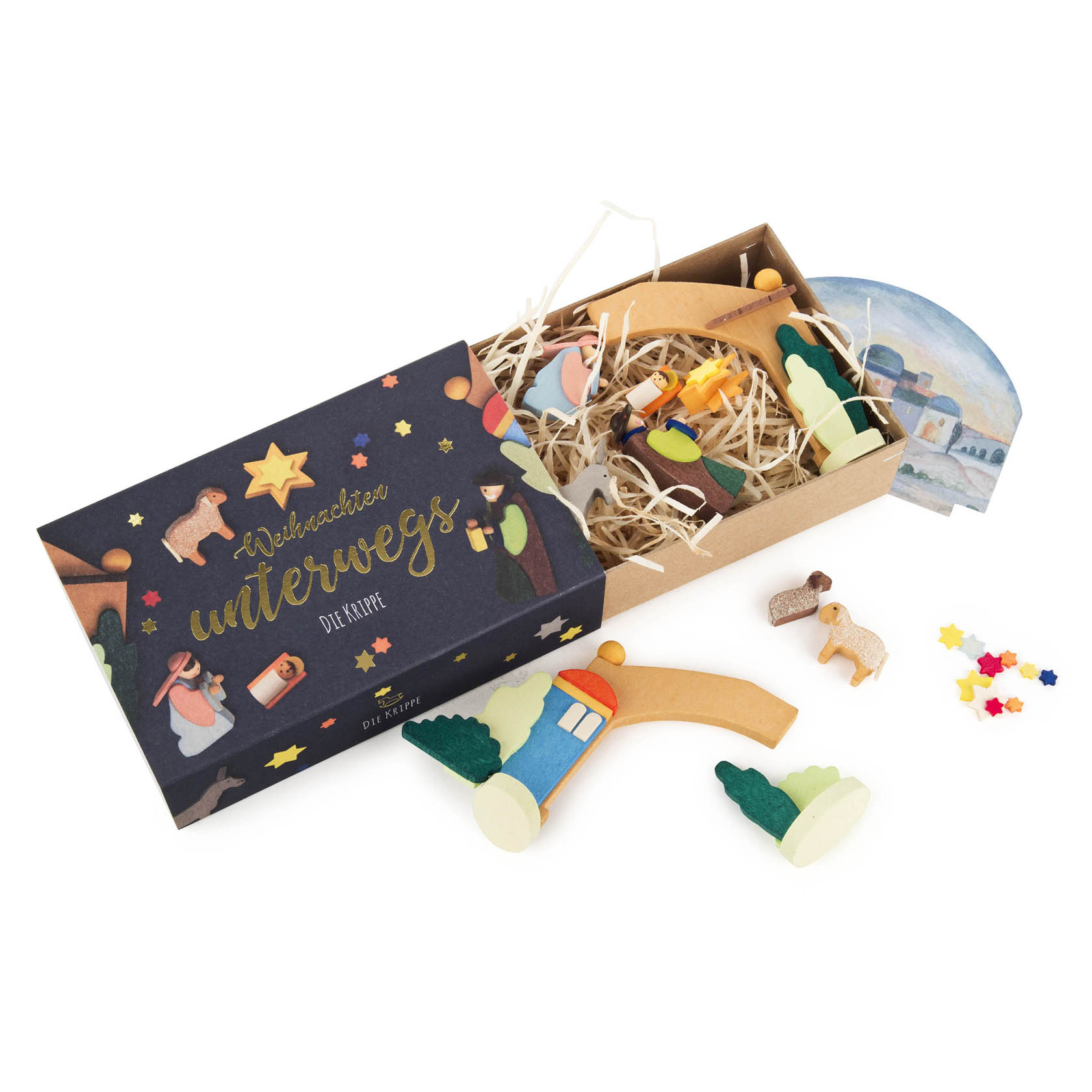 Miniatur-Weihnachtskrippe bestehend aus einer Schachtel mit beschriftetem Deckel, Holzfiguren, darunter ein Zug, Bäume und eine Kulisse.