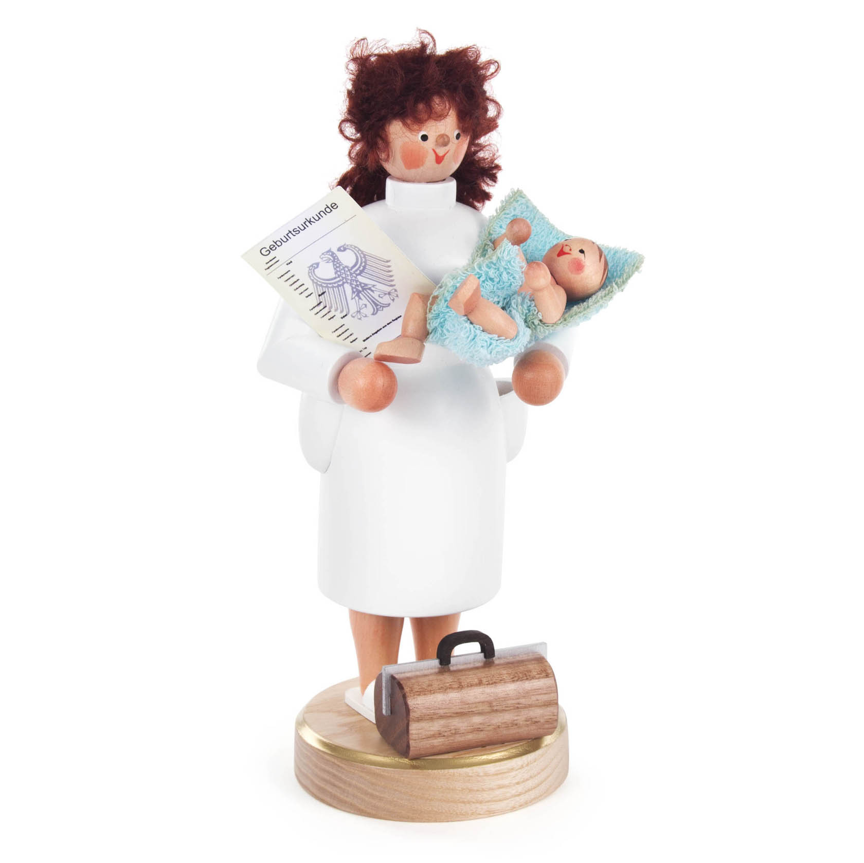 Holzfigur einer Hebamme mit roten Locken, weißem Kittel, hält ein Baby in einer blauen Decke und ein Dokument, Fuß mit Werkzeugkoffer. im Dregeno Online Shop günstig kaufen