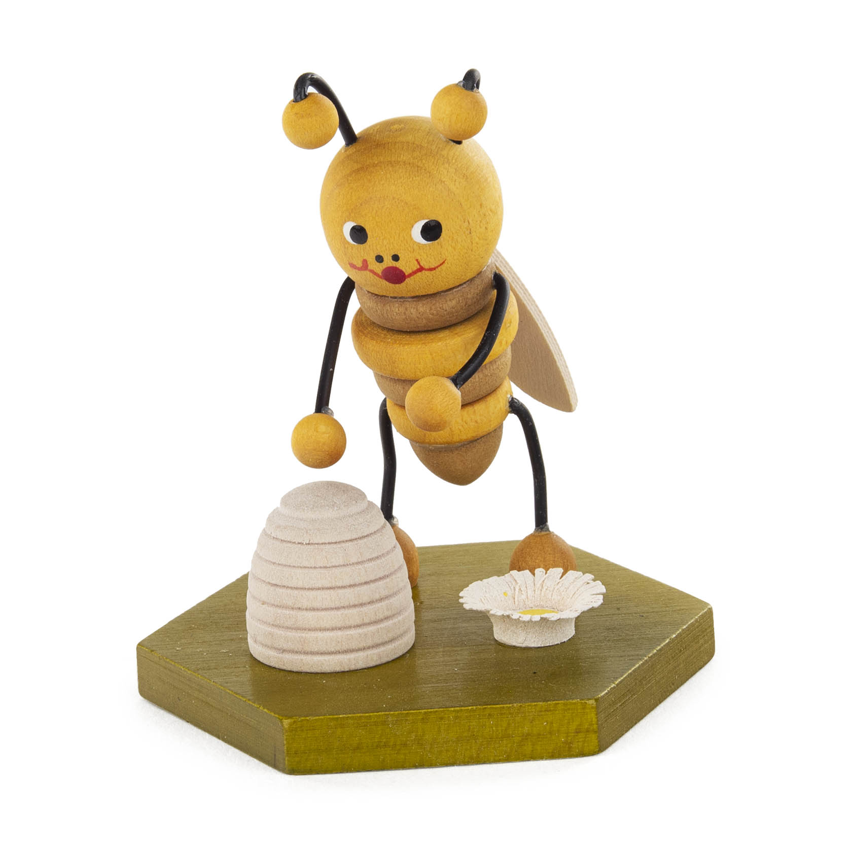 Holzfigur einer niedlichen Biene mit fröhlichem Gesicht, die neben einem kleinen Bienenkorb auf einem grünen sechseckigen Sockel steht, mit einer Blume darauf. im Dregeno Online Shop günstig kaufen