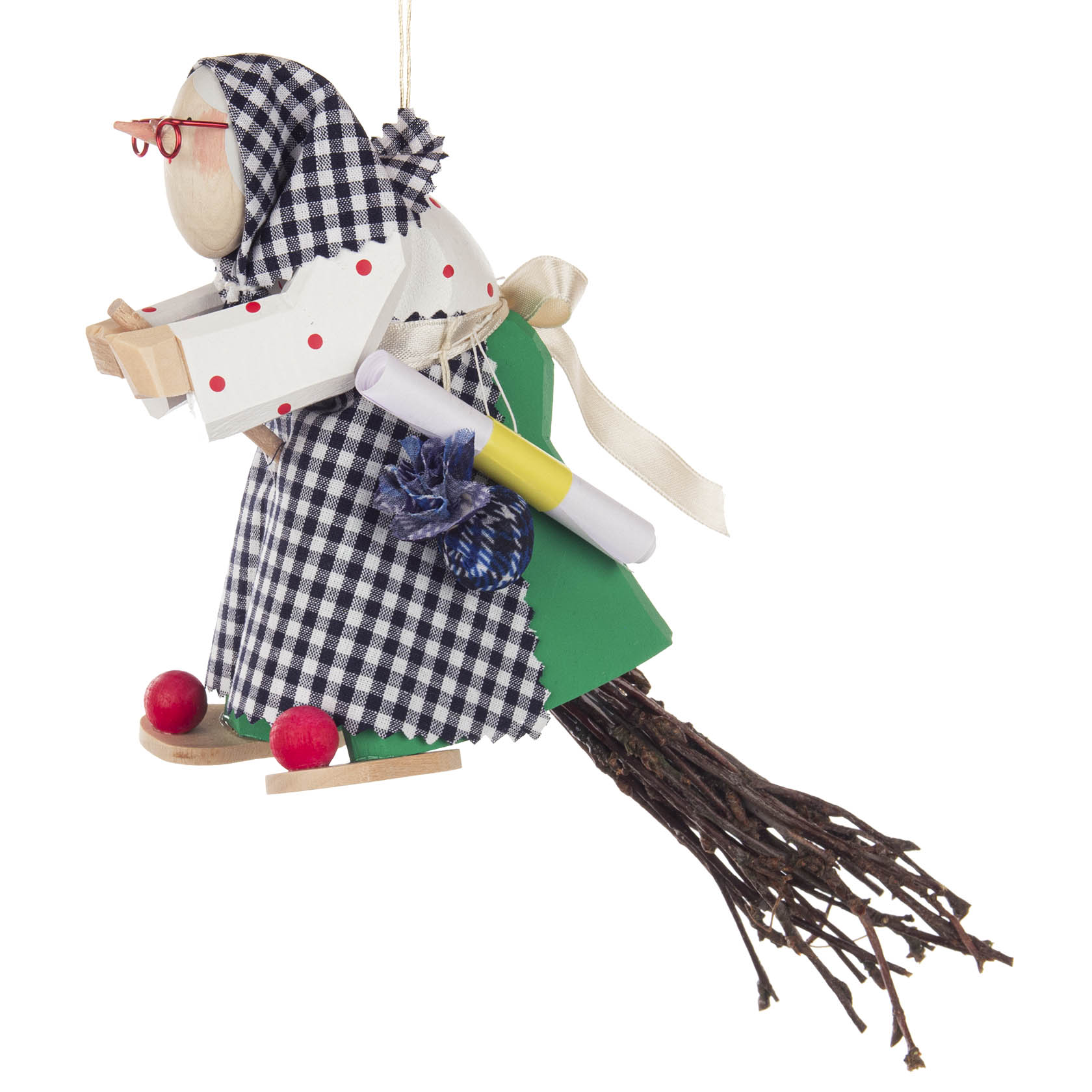 Holzfigur einer geschnitzten Kräuterhexe mit roter Brille, blau-weiß karierter Kleidung und einem Besen. Sie hält ein Buch und hat Accessoires wie Kräuter und Fläschchen.