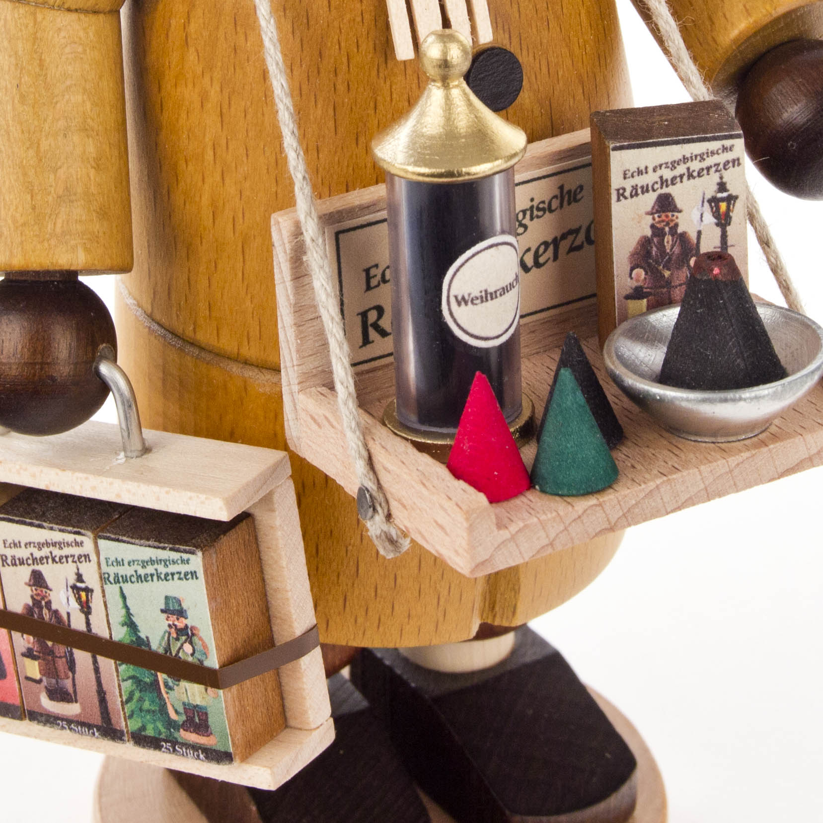 Holzfigur eines Räuchermanns, der einen Kasten mit Räucherkerzen trägt und einen weiteren Behälter mit brennenden Räucherkerzen vor sich hat.