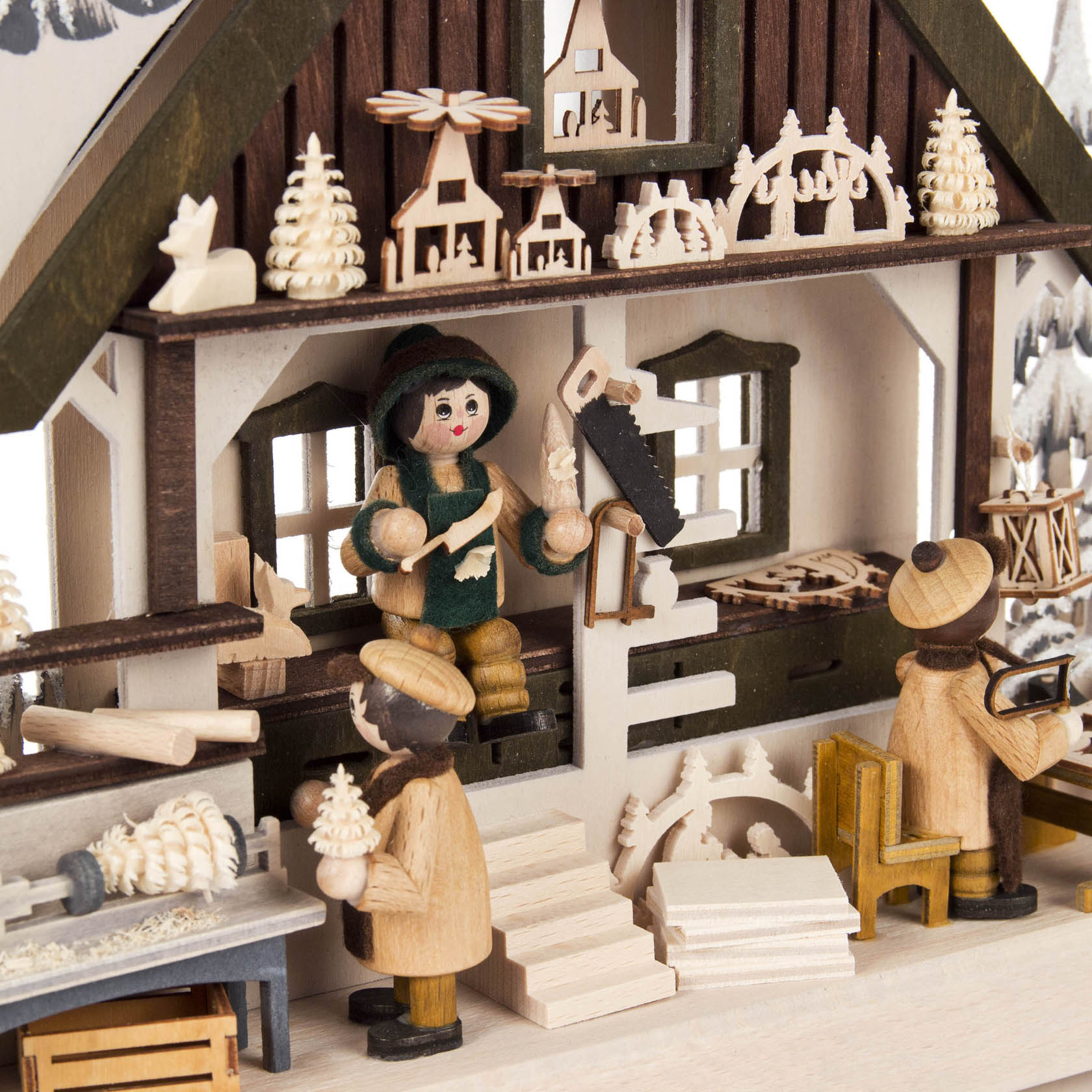 Ein detailreicher Schwibbogen zeigt eine Werkstatt-Szene mit Holzfiguren bei der Arbeit an Holzspielzeug, in einem Haus mit Fenstern und kleinen Dekorationen.