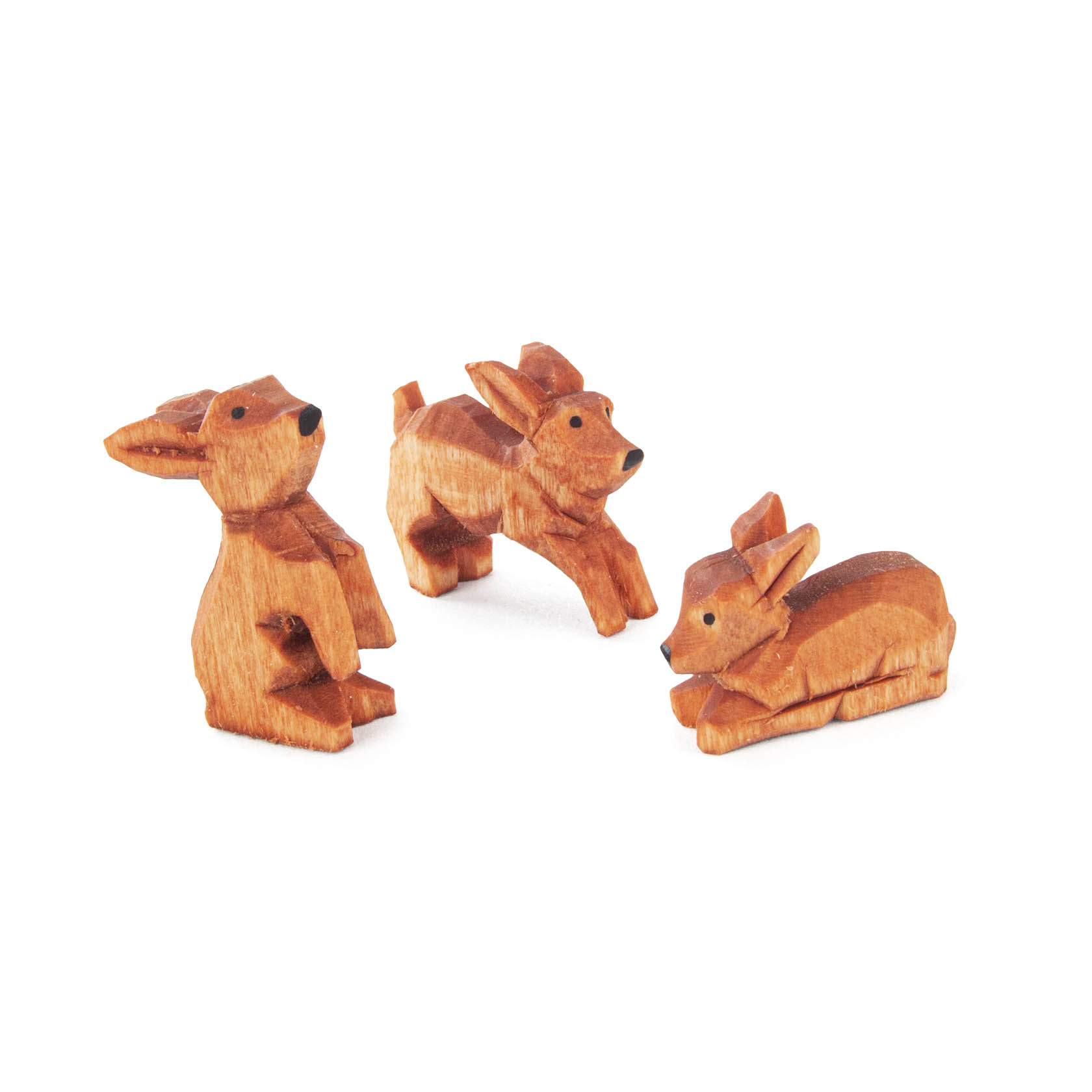 Drei aus Holz geschnitzte Hasenfiguren. Zwei sitzen aufrecht mit nach vorne gerichteten Ohren, während der dritte liegt und entspannt wirkt. im Dregeno Online Shop günstig kaufen