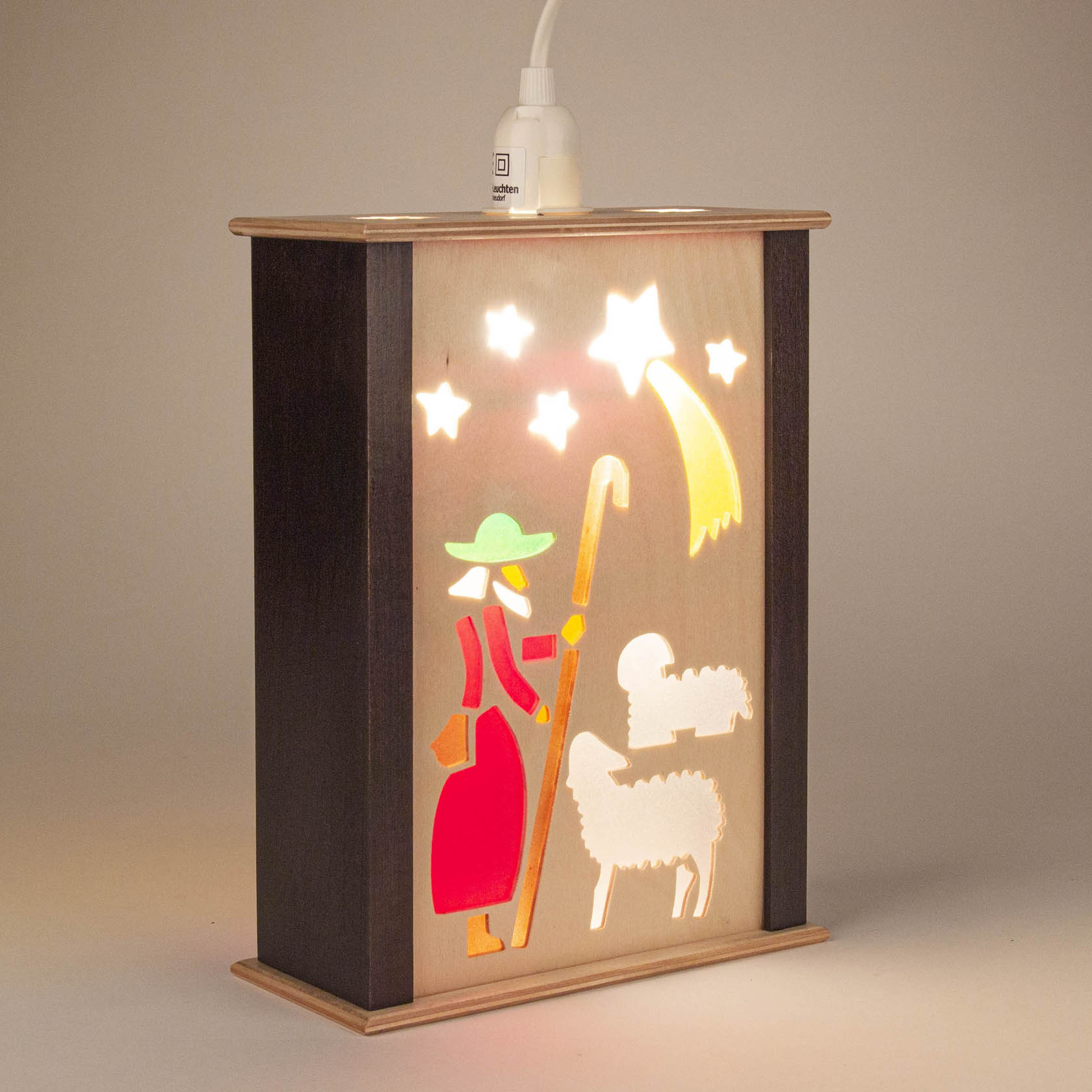 Illuminated festive lantern depicting a shepherd with a staff, two sheep, and the Bethlehem star in vibrant colors.