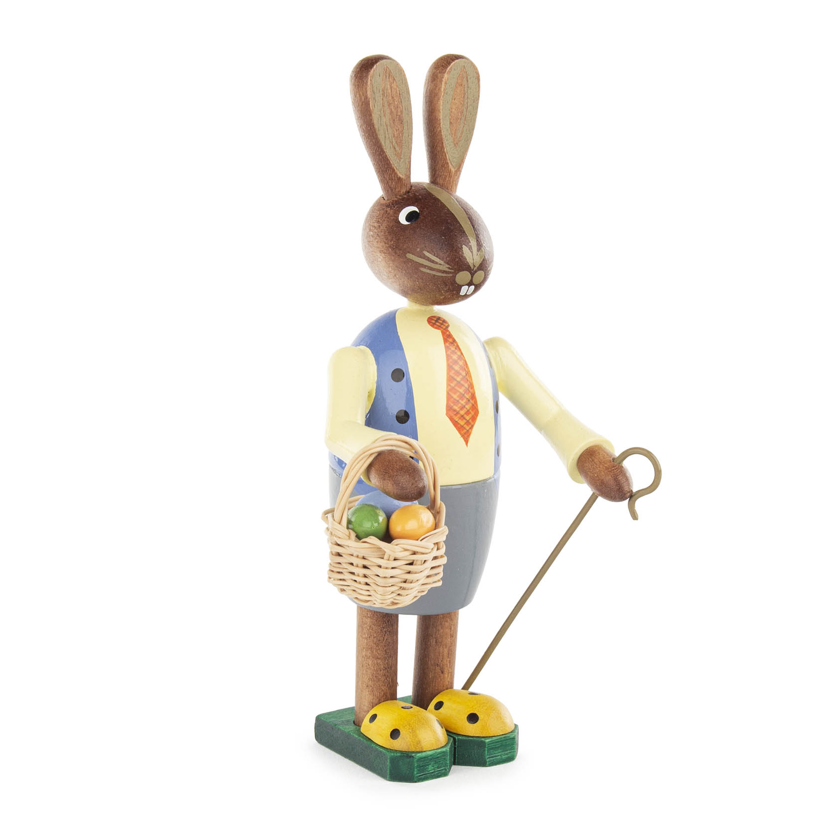 Holzfigur eines Osterhasenmannes, 15 cm, mit blauer Jacke, gelber Krawatte und grauem Rock, hält einen Korb voller bunter Ostereier und einen Spazierstock. im Dregeno Online Shop günstig kaufen