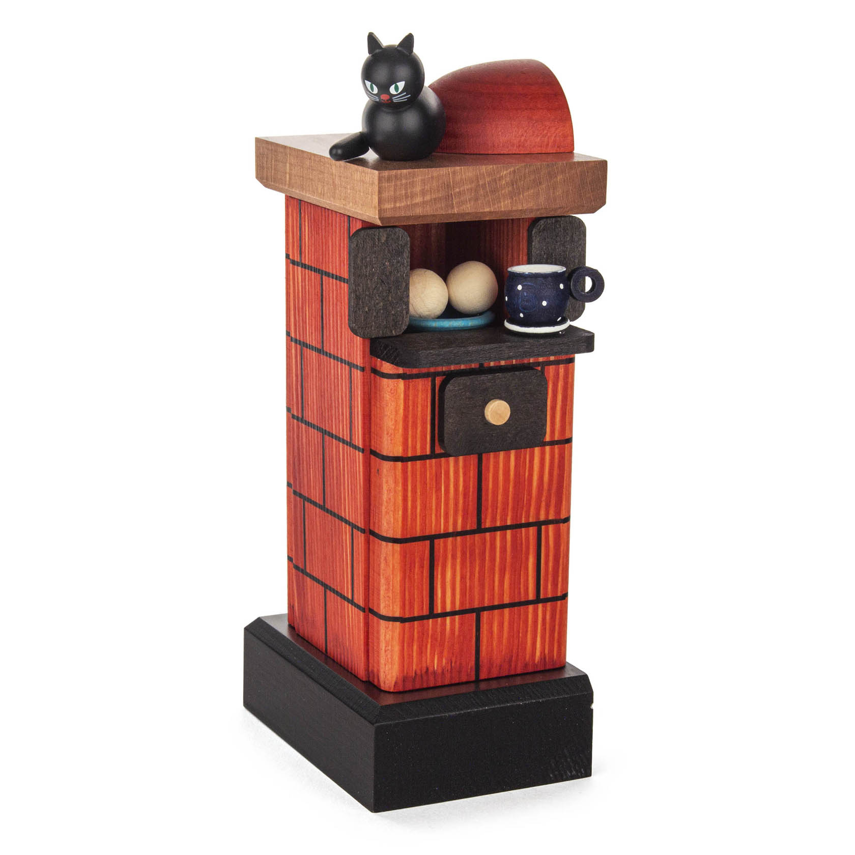 Dekorativer roter Räucher-Kachelofen mit Katze auf dem Schornstein, schwarzen Akzenten, einer kleinen Schublade und Tasse auf dem Sims. im Dregeno Online Shop günstig kaufen