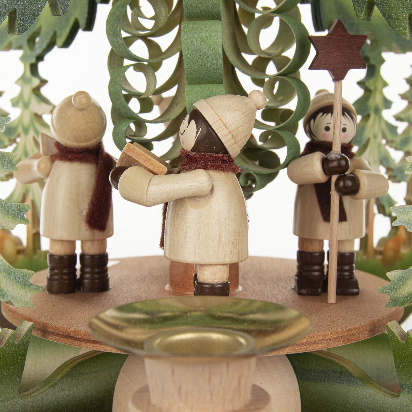 Holzpyramide mit drei Kurrendesängern, die Liedblätter halten. Einer trägt einen Stern. Die Figuren sind unter einem stilisierten Weihnachtsbaum.