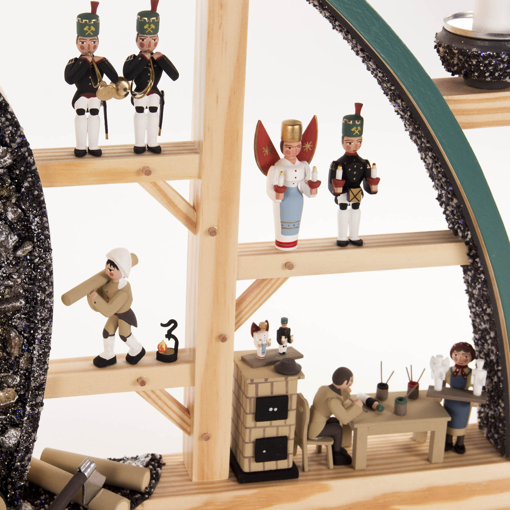 Ein Schwibbogen zeigt Seiffener Hauer und Erzgebirgsfiguren. Erzgebirgsmänner in Uniformen, eine Engel-Figur und geschnitzte Handwerksfiguren an einem Holztisch.