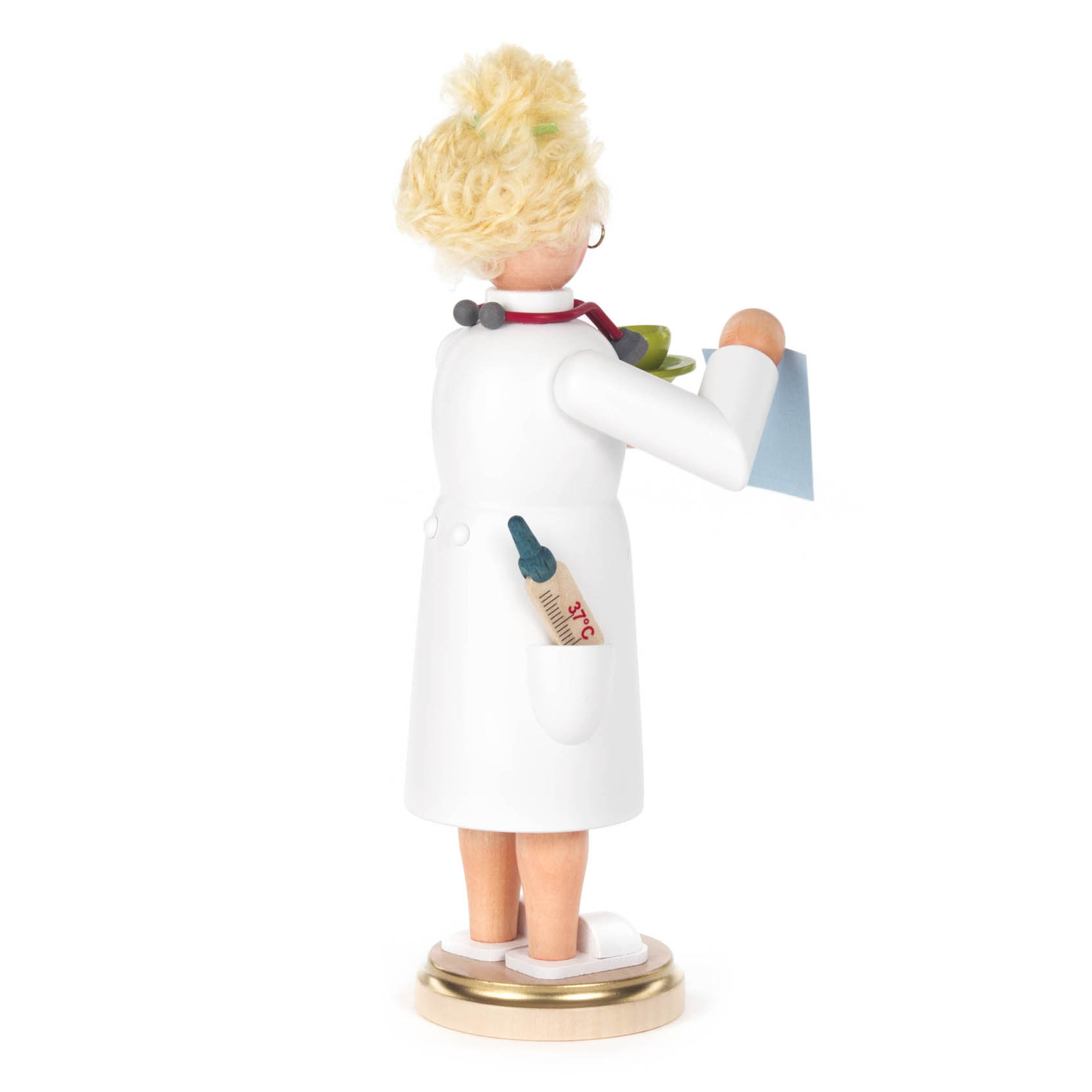 Holzfigur einer Räucherfrau in Gestalt einer Ärztin mit blonden Locken, weißem Kittel, Stethoskop um den Hals und einer Spritze in der Tasche.